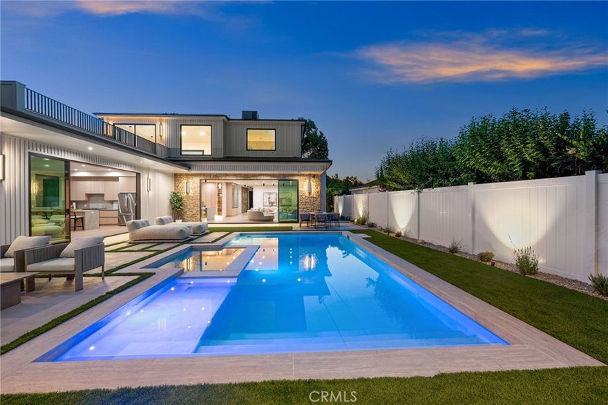 Experience an extraordinary newly constructed estate that redefines modern elegance in the heart of Encino. Completed in 2025 by one of the area’s most acclaimed builders, this architectural modern farmhouse is a sanctuary of artistry, design, and comfort. From the moment you arrive, the gated entrance and striking curb appeal set the tone for what lies beyond. Inside, soaring ceilings, a dramatic stone feature wall, and wide-plank European oak floors create a seamless blend of grandeur and warmth. Venetian plaster finishes, designer lighting, and custom millwork highlight the impeccable craftsmanship throughout. The gourmet kitchen is nothing short of breathtaking, showcasing imported porcelain countertops, an oversized island with smart storage, professional-grade appliances, and a wine & beverage cooler. The dining room dazzles with a built-in glass display cabinet with sleek black framing and soft backlighting, a gallery-like feature perfect for luxury dining, the expansive family room centers around a statement fireplace, evoking the serenity of a Tulum resort while capturing the sophistication and relaxed elegance of modern California living.The private backyard five-star retreat includes: sparkling pool & spa, outdoor kitchen with BBQ, bar seating, and a covered patio with heaters, perfect for year-round entertaining. A 2-bedroom ADU offers complete independent living with its own kitchen, bathroom, and living room. With both a private side entrance and sliding doors to the backyard, ideal as a guest house, office, or pool cabana. The main level also features a cinema room designed for the ultimate movie night experience, ensuite guest bedroom, mudroom & a stylish powder room. Ascend the floating staircase, accented by an impressive indoor garden seamlessly blended into the floor design & illuminated with lighting, leading to 4 spacious ensuite beds upstair, including a luxurious primary retreat with a rooftop-style balcony, fireplace, oversized walk-in closet, and spa-inspired bath with soaking tub, dual rain shower, and dual vanities. Additional amenities include a smart home system with speakers, security cameras, alarm, and gated driveway with intercom. Located within the Encino Charter Elementary district and moments from Ventura Blvd’s premier dining and shopping with effortless freeway access, this estate embodies the best of design, lifestyle, and location. This is not just a home, it’s a statement of elegance, artistry, and elevated living.