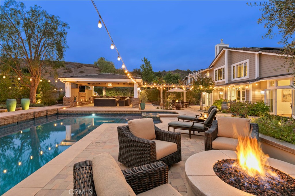 Luxury, Privacy & Resort Living in Coto de Caza!
Experience California resort-style living with this exquisitely remodeled 4-bedroom, 3-bathroom home, ideally located on a peaceful cul-de-sac in the heart of Coto de Caza. This home exudes outdoor living and entertaining at its best!
Enter through double doors to soaring cathedral ceilings and elegant finishes throughout. The designer kitchen showcases quartz countertops, premium appliances, and a spacious walk-in pantry, while the breakfast nook offers a serene space to start your day. A main-floor bedroom adds flexibility as a guest room, office, or quiet escape. The spa-inspired primary suite features a fireplace and custom-designed closets.
Upstairs, a generous bonus room with fireplace invites versatility—perfect for a theater, game room, office, gym, studio, or additional lounge.
Set on an expansive 11,050 sq ft lot with no rear neighbors, this 3,421 sq ft home includes a 517 sq ft covered entertainer’s patio. The backyard is designed for elevated living, complete with a heated gunite saltwater pool and spa, tranquil water features, sauna, fire pit, and chef-style outdoor kitchen with pizza oven, BBQ, beer fridge, warming drawer, and refrigerator. Lush landscaping including mature fruit trees, grapevines and hillside views create a peaceful backdrop, with a chandelier, outdoor fireplace, speakers, lighting, and a mounted TV for all-season enjoyment.
Additional features include paid-off solar, split-zone HVAC, EV charger, water softener, fiber cement siding, central vacuum, attic fan, and French doors.
Conveniently located near scenic trails, parks, the Coto de Caza Golf & Racquet Club, and schools served by a highly rated district.
A rare opportunity to own a home that blends luxury, flexibility, and lifestyle. Enjoy NO MELLO ROOS! Schedule your private tour today!