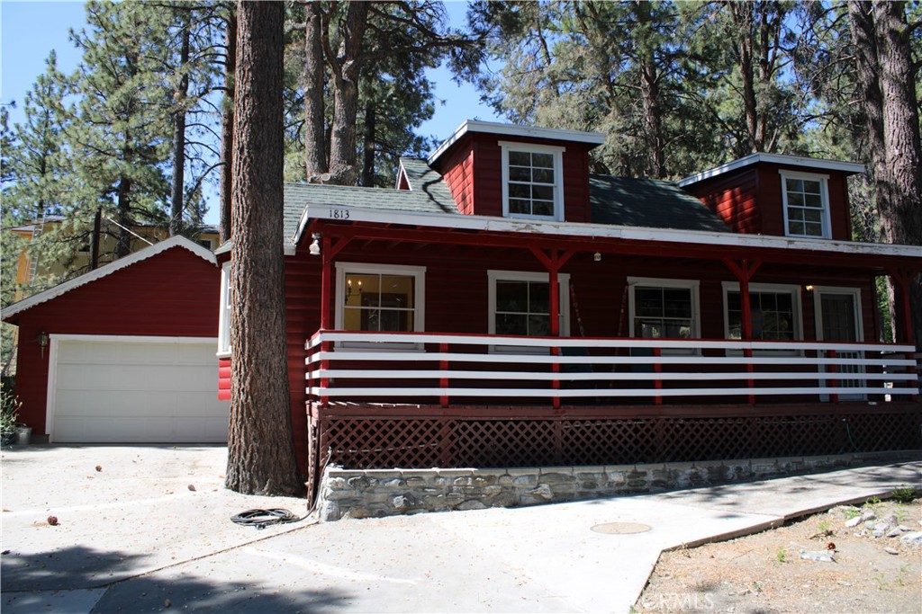 Wrightwood charmer on a corner lot!! Featuring 2 bedrooms, 1 full bathroom and a 2 car garage with the most adorable front porch you could ask for! Large concrete driveway, fenced rear yard and curb appeal galore! Location is ideal, perfectly situated between frequently plowed County roads in the winter and close but not to close to State highway 2 and Lone Pine Cyn Rd for easy commuting options. Centrally located and an easy 10 minute walk to the heart of the Village with shops and restaurants and Summer festivities. Feel the relaxing vibes with your wood burning fireplace that opens to the kitchen and ding area, and a large bedroom on the main floor that easily fits the Cali King. Full bathroom on the main level as well, with a slider off the hall to your relaxing rear deck nestled amongst the pines. Upstairs, a large loft bedroom with peek-a-boo dormer windows can easily sleep 4, perfect for the grand kids. Looking for a full or part time rental option to earn some income vs. mortgage payment? This is the PERFECT HOME for a weekend getaway, with plenty of parking, basketball hoop for the kiddos or the young at heart! Come see one of the most adorable homes Wrightwood has to offer!