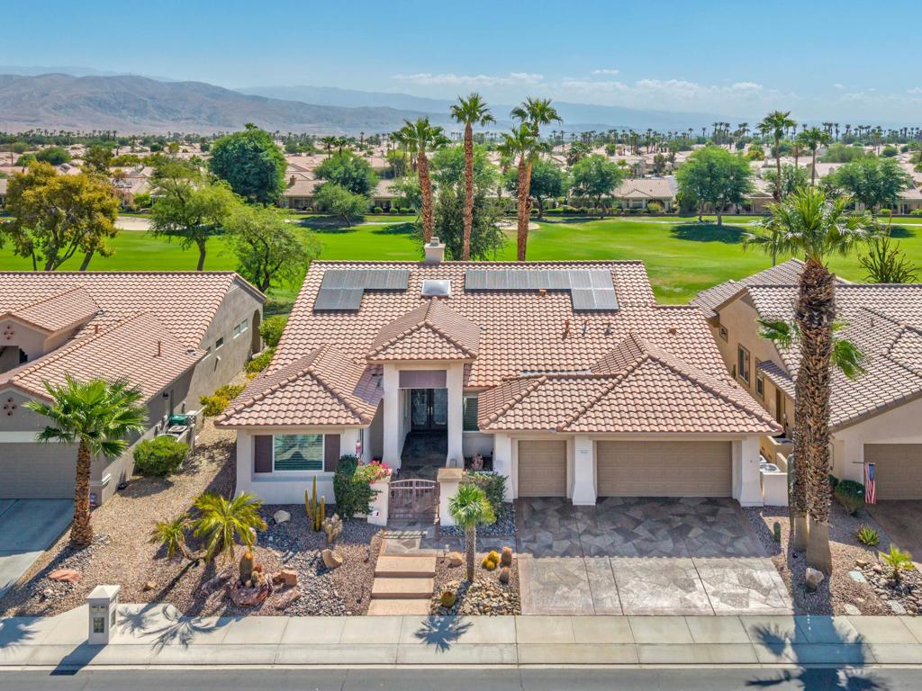 Sun City Palm Desert - St. Tropez. This sought-after St. Tropez model is one of Sun City's most dramatic great room floorplans--elevated on the 14th fairway of the Santa Rosa course with panoramic golf course and mountain views. The east-facing backyard is designed for entertaining, featuring an expanded decorative concrete patio, multiple seating areas, desert landscaping, and three gas firepits. Curb appeal shines with a decorative concrete driveway, gated courtyard, and leaded-glass double doors. Recent upgrades make this home move-in ready for the desert climate: new dual AC units (2024), owned solar eliminating electricity bills, and upgraded windows throughout. Inside, soaring 12-foot ceilings in the great room and foyer, upgraded lighting, and Hunter Douglas window treatments create a dramatic yet comfortable atmosphere. Diagonally laid 19-inch tile flows through the main living areas. The great room showcases a granite-surround fireplace, a granite-topped wet bar with refrigerator, and a wall of windows framing the view. Double doors open to a flexible den/office. The kitchen is a chef's delight with granite counters, a large breakfast bar, center island, wall oven, and pull-out cabinetry. The primary suite offers double-door entry, patio access, a custom walk-in closet, and a spa-style bath with dual sinks, sitting vanity, oversized soaking tub, and glass-block shower. A spacious guest suite includes its own full bath. Additional features: large laundry with storage and sink, 2-car + golf cart garage with epoxy floors and separate AC, and the option to purchase furnished outside of escrow.