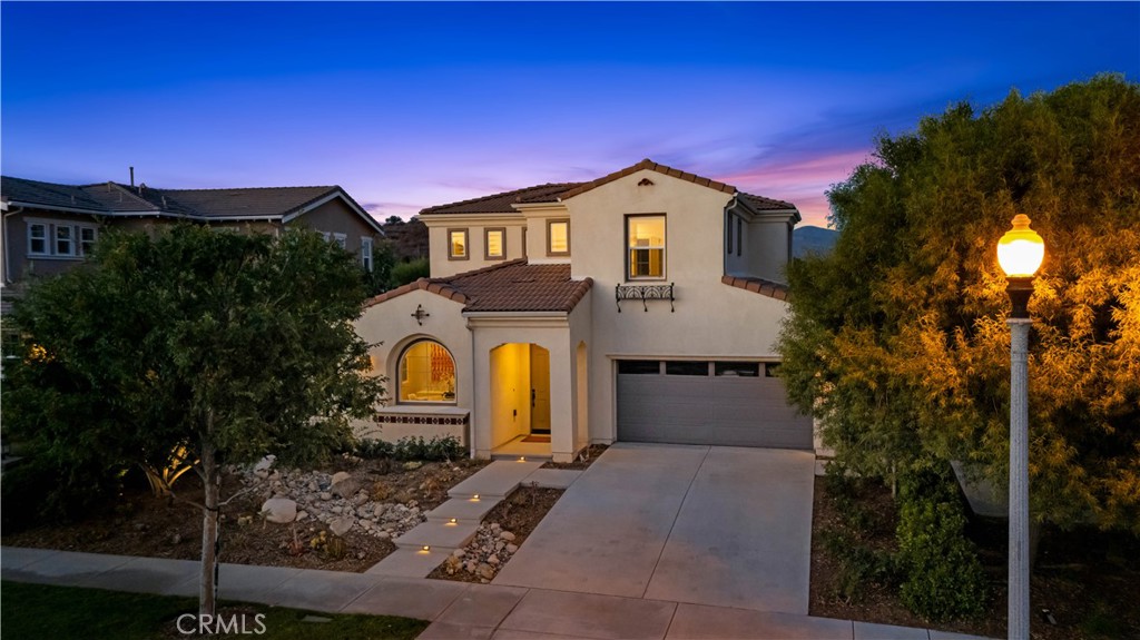 MAIN FLOOR PRIMARY SUITE, in Gated Valencia West Hills with BREATHTAKING VIEWS. Welcome to your dream home: beautifully designed with sweeping valley and hillside views in one of Valencia’s most sought-after gated communities! This stunning property blends elegance, comfort, and functionality, with modern fininishes, tall doorways, and expansive windows offering plenty of natural light. The open-concept family room boasts a sleek modern fireplace with custom recessed wall features, and seamlessly flows into the living spaces on the main floor. The kitchen features a generous center island with seating, a built-in wine fridge, elegant granite countertops with mosaic tile backsplash, under-cabinet lighting, built-in range, double ovens, walk-in pantry, and stainless steel appliances. A formal dining room with custom European cabinetry provides the perfect setting for gatherings, with a full guest bath on the main level. The spacious main-floor primary suite is a true retreat, featuring an open layout, walk-in closet with custom built-ins, and direct backyard access where you can soak in the gorgeous views! The luxurious ensuite bathroom offers dual sinks, abundant counter space and storage, a soaking tub, separate shower, and a private water closet. Upstairs, a well appointed loft offers flexible living space, with two additional bedrooms featuring walk-in closets plus access to a full bath with dual vanities and a tub/shower combo. The backyard is a luxe low-maintenance entertainer’s paradise, thoughtfully landscaped with hardscape accents, a built-in fire pit, and plenty of space to relax or host, all framed by incredible panoramic views! Convenient indoor laundry room + 2 car garage. The Valencia West Hills HOA offers resort-style amenities including multiple pools, spa, sports court, playground, clubhouse, and controlled access. All this, just minutes from top-rated schools, shopping, dining, and freeway access—while still enjoying the privacy of a gated community!