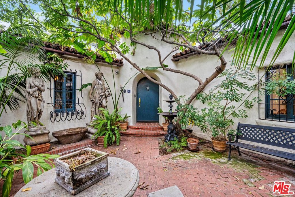 Hidden behind lush greenery and towering trees, this thoughtfully curated and offered fully furnished 1928 Spanish retreat offers 2 bedrooms, 2 bathrooms, and timeless California charm. Blending original wrought iron, colorful tile work, arched doorways, and exposed beams with warm wood floors and abundant natural light. The primary suite includes a cozy sitting area and Juliet balcony overlooking the private outdoor sanctuary. Perfect for entertaining or unwinding, the grounds feature al-fresco dining, a sparkling pool, and tranquil water features. Set in coveted Hancock Park, just moments from museums, fine dining, shopping, and the charm of Larchmont Village, this home captures the essence of elevated Los Angeles living. Call/text listing Agent 1