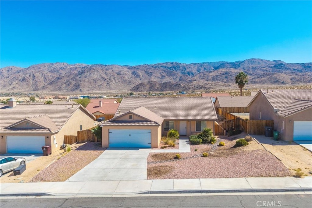 Gorgeous turn keyhome ready to be yours. Offered at $350k Sun Valley Drive is a four bedroom, two full bath home with a great entertainers backyard located in the desirable Chocolate Drop neighborhood of Twentynine Palms. New carpet in the living room and bedrooms and a fresh interior paint compliment the great layout. The kitchen is well appointed with a gas stove/oven, a dishwasher and a good sized pantry. The bedrooms are nicely sized as well with a large primary bedroom that boasts two walk in closets and an ensuite bathroom with dual vanity sinks. The living area has a cozy fireplace and really nice natural light coming in from the large windows. One of the bedrooms in the front of the home and would make for a nice office or studio. Some other nice attributes to the home are central heating and air and an energy efficient Mastercool swamp cooler, an abundance of storage, a separate laundry area within the home, the two car garage with finished walls, the big backyard with wood privacy fencing that looks out over the homes in back providing striking views of the mountains that are in fact the backside of Joshua Tree National Park, and the well maintained neighborhood that does not have HOA's.
Located near to all that the high desert has to offer this home is under 8 miles to the main entrance of Joshua Tree National Park and less than 10 minutes to the Marine Corp's base. Also, it is only 5 minutes to downtown 29 Palms and its eclectic restaurants and shops and the newer Freedom Plaza which hosts a weekly farmers and art market as well as community events and entertainment. Come make this beautiful home your own home sweet home.