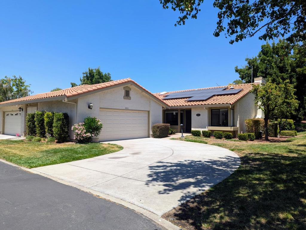Fabulously remodeled single level end unit in The Villages Golf & Country Club, an active senior community; one person to be 55+. Amazing island kitchen with Cambria quartz counters, cherry cabinets, custom vineyard scene backsplash, under and accent cabinet lighting, and two pantries including one walk-in pantry. Wine bar with wine refrigerator and glass front and back wine glass cabinets. Separate dining room. Living room features vaulted ceiling, suntunnel, and wood burning stove with custom carved travertine stone. Gorgeous lake views -- perfect for outdoor entertaining. Remodeled primary bathroom with custom tile shower and dual sinks with granite counters. Large walk-in closet in primary suite. Sliding doors from living room and both bedrooms lead out to rear patio. Dual-pane windows & doors, tumble travertine and hardwood flooring. Skylights in kitchen and baths. Solar panels with battery storage. Huge garage with storage lifts & cabinets. Golf cart included in sale. HOA fee includes Golf Membership, gated access, Water/Sewer/Cable TV/Garbage, Community newspaper,18 hole golf course, 4 Swimming Pools, 6 Tennis Courts, 3 Bocce Ball courts, 4 Pickleball Courts, Exercise Facility, two restaurants, Library and a US Post office, and more!. Don't miss this one!