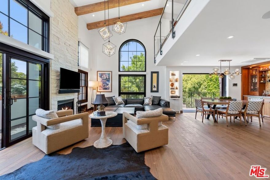 Located on Montana Avenue in one of Santa Monica's most desirable neighborhoods, this tri-level townhouse offers a rare blend of high design, privacy, and indoor-outdoor living. Reimagined in 2022 by PKA Architecture with interiors by Carole Carr Design, the 2-bed, 2.5-bath home includes a versatile loft, four private outdoor spaces, and a private two-car garage with direct entry. Custom finishes include wide-plank European white oak floors, 14-foot reclaimed wood beams, a wood-burning fireplace with travertine hearth and limestone surround, and Fleetwood pocket doors. The kitchen and custom walnut barcrafted by Four Board Woodworks, features Patagonia quartz, antique glass, and SubZero and Miele appliances. Smart and sustainable living is fully integrated with a Control4 system, Lutron LED lighting, Tesla Powerwall, whole-home water purification, and built-in speakers throughout. Upstairs, the loft opens to a rooftop retreat with a built-in BBQ kitchen, outdoor TV perfect for entertaining or working from home. The primary suite features a custom closet, radiant heated floors, blackout shades, and a private patio with slate tile and mahogany fencing. Every inch of the home, including the laundry room, is thoughtfully designed with premium materials and timeless craftsmanship.