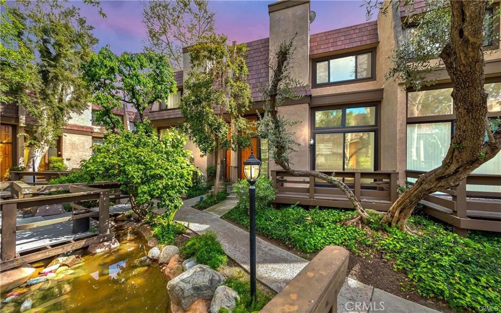 Fully Renovated Northridge Townhome – Spacious, Prime Location, Move-In Ready. Welcome to this beautifully remodeled 2-bedroom, 2-bathroom townhome in one of Northridge’s most sought-after communities. Perfect for first-time buyers, professionals, and investors. This immaculate home offers the ideal blend of modern upgrades, effortless comfort, and unbeatable convenience. Step inside and be welcomed by a chic chandelier in the foyer, setting the tone for the elegant interior. The bright, open-concept living space features luxury waterproof vinyl plank flooring, custom zebra blinds, and brand-new dual-pane energy-efficient windows throughout. The spacious living room opens onto a private balcony—perfect for enjoying morning coffee, taking in sunset views, or entertaining guests. The chef’s kitchen is both functional and stylish, complete with quartz countertops, a designer tile backsplash, stainless steel appliances, and custom cabinetry in the dining area for added spacious storage. The primary suite is a true retreat, showcasing a spa-inspired bathroom with dual sinks, sleek LED mirrors, a glass-enclosed rainfall shower, and high-end tile finishes. The secondary bedroom is equally spacious and served by a fully renovated bathroom with a new tub, modern fixtures, and an LED mirror. A stylish powder room with LED lighting adds extra convenience and flair for guests. Key Features & Upgrades: Brand-new energy-efficient windows, New Whole-house water filtration system, Direct-access 2-car private garage, Luxury waterproof vinyl plank flooring, Custom zebra blinds on every window Enjoy resort-style amenities, including a sparkling swimming pool, tennis courts, tranquil water features, ample guest parking, and 24-hour security. HOA dues cover water, sewer, earthquake insurance, and a completed earthquake retrofit (2020), as well as a new roof (2023). A nearby bus stop offers excellent commuter access. Situated in a prime location, you're just minutes from CSUN, Vanalden Park, Porto’s Bakery, Costco, Northridge Fashion Center, restaurants, shops, and theaters—everything you need is right around the corner. Don’t miss this rare opportunity to own a fully updated, move-in-ready gem in the heart of Northridge. Schedule your private showing today!