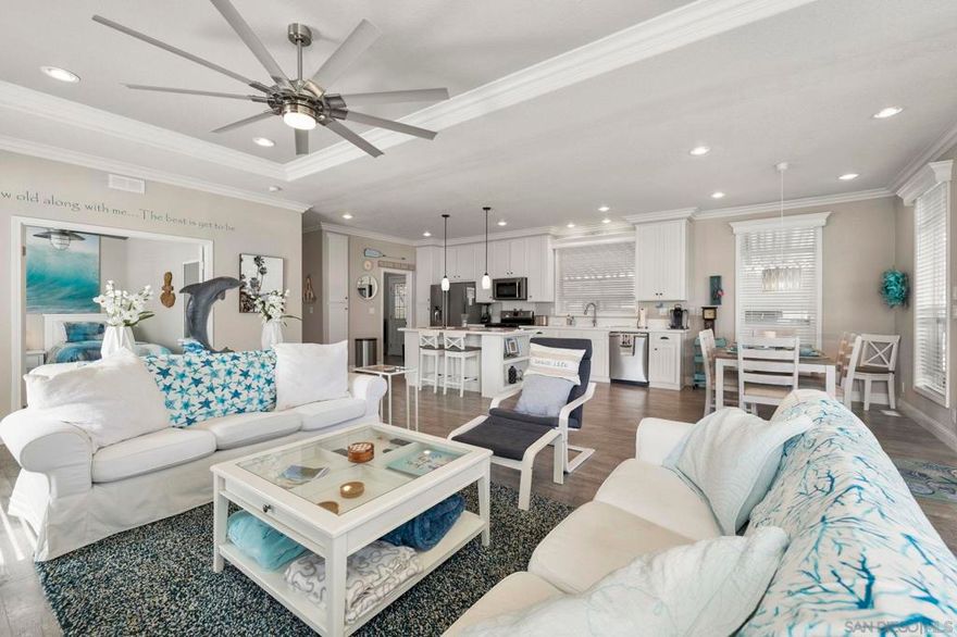Welcome to paradise with a stunning lake and greenbelt view! Built in 2016, this is a beautifully maintained three bedroom, two bath manufactured home located in the highly desirable 55+ gated community of Lakeshore Gardens in Carlsbad. A meticulous masterpiece featuring a panoramic view of the greenbelt and lake with a full-length deck across the rear of the home. Furnishings throughout are included with the sale! Expansive dual pane windows and double patio doors filling the living and kitchen with natural light.  Bright and open floor plan with vaulted ceilings. Spacious open living and dining areas flow into a well-designed kitchen featuring stainless steel appliances, plenty of cabinetry and counter space with an extended island for all your cooking and entertaining needs. Upgraded ceiling fans located throughout the home. Combination air conditioning and heating unit. Primary suite provides a private retreat with ample closet space and main bathroom with a gorgeous tiled shower. An additional bedroom off of the living room has double doors and is perfect for guests, hobbies, or even a home office. Step outside to a large covered deck and low-maintenance yard with artificial turf—ideal for morning coffee, ocean breezes, or gathering with friends. Lakeshore Gardens is one of Carlsbad’s most sought-after 55+ communities offering resort-style amenities including a clubhouse, heated pool, spa, fitness center, and beautifully landscaped walking paths. Plus, coast highway and the beach is just a distance away! Minutes from shopping, dining, and everyday conveniences, this home offers the ideal blend of comfort and lifestyle!