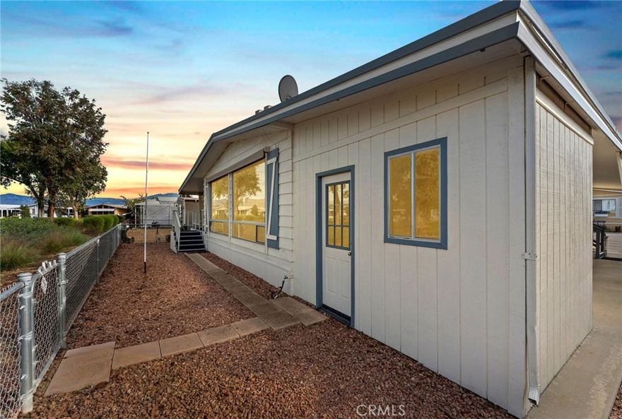 Step into your dream oasis with this exquisite 2-bedroom, 2-bathroom mobile home, perfectly situated on the golf course, offering stunning floor-to-ceiling windows that frame breathtaking mountain and fairway views. This updated and turnkey abode invites you in with its spacious bonus room and finished California room, ideal for entertaining or relaxing. The elegant formal living and dining areas are complemented by modern conveniences, including all appliances—washer and dryer included, both less than three years old! Indulge in the luxurious primary suite, boasting a sophisticated bathroom with a vanity area, a separate soaking tub, and a walk-in shower for your private retreat. Enjoy peace of mind with recent upgrades, including a new AC and water heater installed in 2019, as well as a roof installed in 2014, recently maintained to extend its life. With custom automatic window shades providing effortless elegance and accessibility features like a low-grade wheelchair ramp, this home caters to every need. A custom oversized storage shed and a large fenced yard await your furry friends, while the exclusive 55+ golf course resort community offers a vibrant lifestyle filled with social activities, from live music and taco Tuesdays to ample opportunities for golf, pickle ball, and shuffleboard. With picturesque lakes, stunning lighted fountains, and facilities that include a gym, outdoor BBQ areas, and a large dog park, this home isn’t just a place to live; it’s a gateway to a fulfilling lifestyle where every day can be an adventure. Don’t miss the chance to call this gem your own!