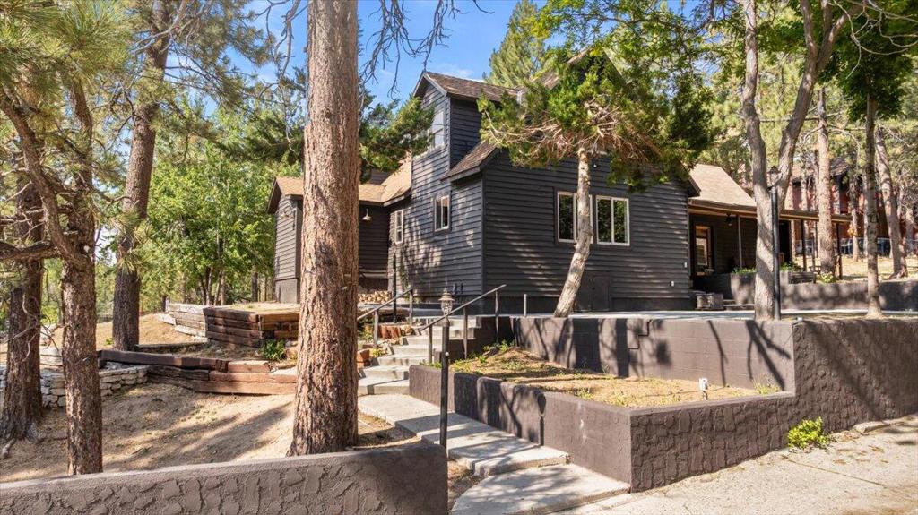 Welcome to this gorgeously remodeled mountain retreat in a prime location! This fully remodeled 4 bedroom, 4 bath home offering 2,600 sq ft of living space on an expansive 25,000+ sq ft lot, this property is just minutes away from the village, lake, ski resorts and all that Big Bear has to offer, perfectly positioned for your year round enjoyment! Inside, no detail has been overlooked. The open concept living area is warm and inviting with custom finishes and plenty of natural light. The ultimate entertainment space awaits- complete with game room and custom built bar, ideal for hosting friends, family or vacation guests. Step outside to enjoy the tranquility of your oversized lot with plenty of room for outdoor entertaining or expansion. Home will come with plans to add decks and spit the lot if desired.Whether you are seeking a full time residence, vacation getaway, or investment property, this stunning, turn-key home offers it all, mountain charm with modern elegance.