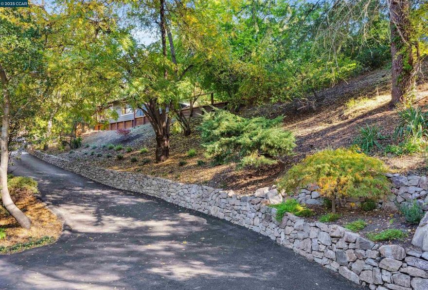 Ideally located within minutes to shopping, dining, entertainment, BART, and easy freeway access to both Hwy 24 and 680, this beautifully remodeled rustic rancher captures the best of Lafayette living — convenience, character, and comfort. Set gracefully above the road, the property makes a striking first impression. A long private driveway framed by a gorgeous Calistoga stacked stone wall, fresh landscaping, and a pebble parking area leads to this inviting residence. Every detail hints at the thoughtful updates and warmth that await inside. The home features stained white oak floors, a spacious living room with stone fireplace, and a stylish kitchen that opens to a comfortable family room offering the ease of indoor/outdoor living. The charming kitchen will delight any chef with its stainless steel appliances: gas cooktop, double ovens, refrigerator, microwave, instant hot water; marble & granite countertops. The primary suite features charming v-groove paneling, a large walk-in closet, and a spa-like bathroom with barn door entrance. An incredible bonus — the property includes an en suite studio/in-law unit with its own kitchen and private outdoor access. The spacious backyard offers new landscaping and walkways - envision a lush lawn, outdoor kit. and built-in BBQ.