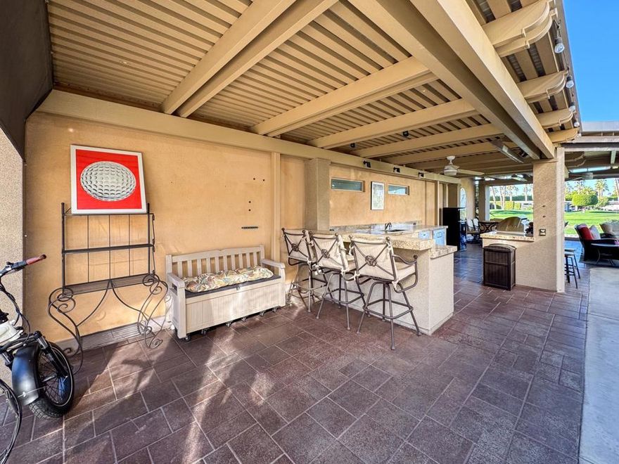 Enjoy the ultimate in outdoor living with this stunning luxury RV lot, featuring breathtaking views of the golf course, lake, and fountains through a grand picture window. The expansive 800+ sq. ft. solid roof pergola provides a shaded retreat, perfect for relaxing or entertaining. Designed with comfort and convenience in mind, the lot includes pavers throughout, parking for two cars, and covered golf cart parking. Located just steps from the pool, laundry facilities, and restrooms, this prime location offers everything you need for a carefree resort lifestyle. Investors take note: This is a prime rental lot that generates income!The outdoor kitchen and entertainment space are a dream for entertainers, featuring over 24 feet of granite countertops, a 7-foot island with a built-in bar, a 32-inch BBQ, GE convection oven, full-size dishwasher, and commercial-grade under-counter refrigerator. The furnished space includes a dining table for eight, a patio couch, swivel chairs, and bar stools. A full stucco privacy wall with inset frosted windows enhances seclusion, while the entertainment center boasts a pop-up 55-inch TV. Comfort is ensured with two ceiling fans, three electric heaters, and two motorized drop-down screens, creating the perfect environment for any occasion. With ambient lighting and stylish finishes, this lot offers an exceptional blend of luxury and functionality, ideal for embracing the RV lifestyle in comfort and style.&#8205;Outdoor Resort Indio is a Class A only RV resort.