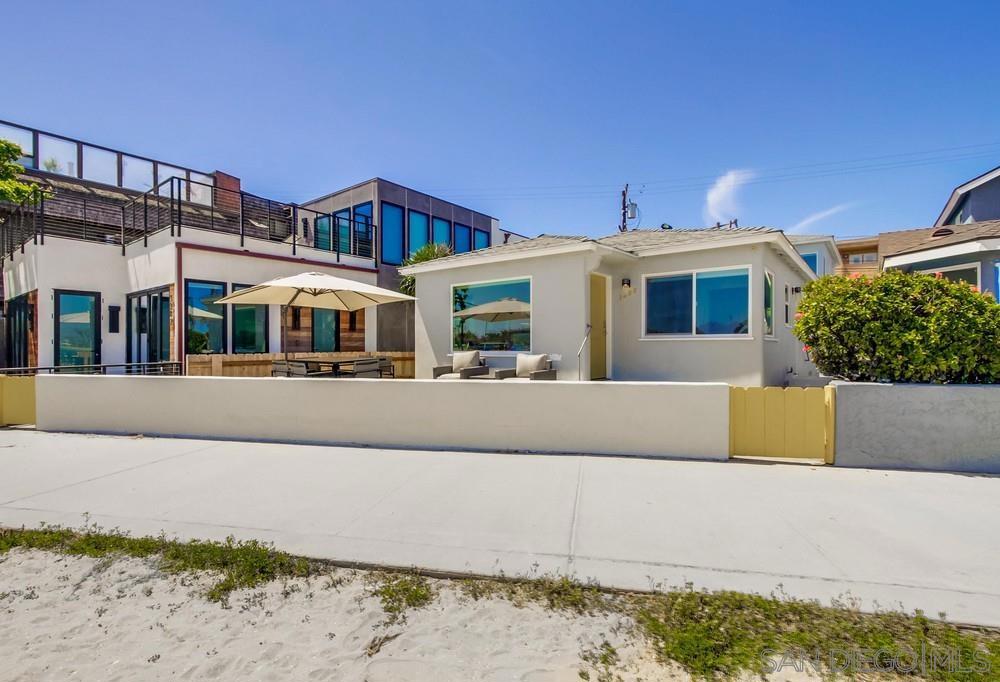 Prime bay-front duplex on Bayside Walk—two detached homes on a 3,179 sq ft lot with an exceptional 1.10 FAR, allowing roughly 3,500 sq ft of future living space. The front cottage, gutted to the studs in 2020, offers two bedrooms, one bath, full A/C, and stunning views open to expansive lawn-style patio where sunrise colors, fireworks, and paddle-boarders unfold at your doorstep. Tucked behind, the bright one-bedroom, one-bath carriage unit crowns a two-car garage, capturing panoramic water views from every window and enjoying its own private entry with no shared walls. Three parking spaces, in-garage laundry, coastal-designer finishes, and turn-key furnishings make this a ready-to-go vacation rental or effortless owner-occupy. Stroll to Belmont Park, ocean waves, cafés, and water-sport rentals in minutes. Assemble with the 4,996 sq ft lot next door, also for sale, to create a landmark bay-front trophy.
