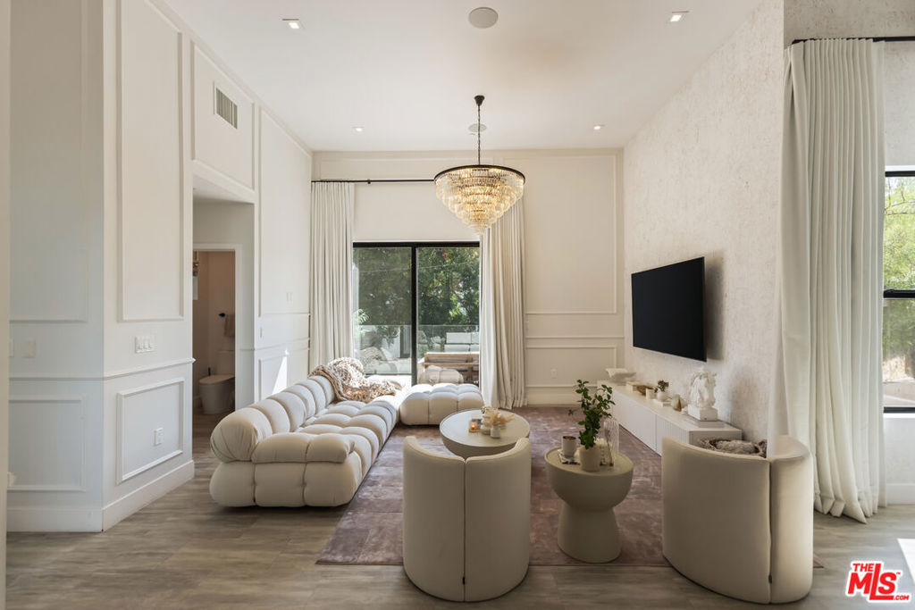 Tucked into the peaceful hills south of Ventura Boulevard, this newly renovated modern home offers an extraordinary blend of style, comfort, and technology. From the moment you enter, you're welcomed by soaring ceilings, abundant natural light, and an open layout that seamlessly connects each living space with effortless flow. Designer touches are found throughout from custom Italian wallpaper accented with 24k gold leaf to refined lime-wash finishes and statement lighting. The chef-inspired kitchen features high-end stainless-steel appliances, a bold center island, and striking Mediterraneo Macchia Antica porcelain surfaces, making it as functional as it is beautiful.The spacious family room, complete with a sleek fireplace, is perfect for cozy nights or entertaining guests. Upstairs, the luxurious primary suite offers a spa-like bathroom with dual vanities, a freestanding soaking tub, walk-in shower, and access to a private balcony with peaceful hillside views. Two additional bedrooms provide ample space, while a separate bonus room/office on the lower level adds flexibility for work or play.A true standout feature is the converted 2-car garage, now a high-performance private gym outfitted with custom flooring, top-tier equipment, and a built-in sauna perfect for fitness enthusiasts or post-workout relaxation.Enjoy complete control and comfort with cutting-edge smart home technology, including Sonos surround sound, NEST thermostat, dual-zone HVAC, tankless water heater, and security-enhancing unbreakable glass.Located just minutes from Westfield Topanga, premium dining, and boutique shopping, this turn-key property offers incredible value in one of Woodland Hills' most sought-after neighborhoods.A rare opportunity at an unbeatable price act fast, this home won't stay on the market for long.