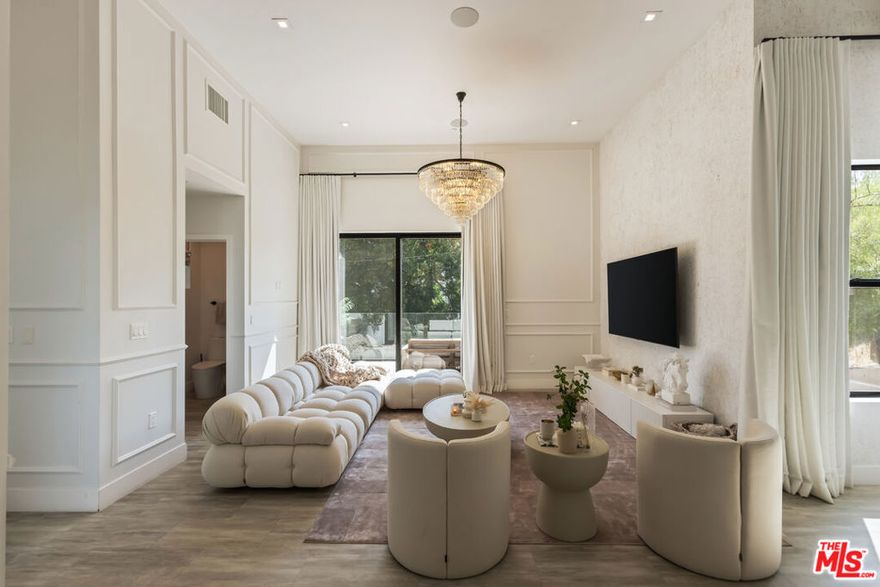 Tucked into the peaceful hills south of Ventura Boulevard, this newly renovated modern home offers an extraordinary blend of style, comfort, and technology. From the moment you enter, you're welcomed by soaring ceilings, abundant natural light, and an open layout that seamlessly connects each living space with effortless flow. Designer touches are found throughout from custom Italian wallpaper accented with 24k gold leaf to refined lime-wash finishes and statement lighting. The chef-inspired kitchen features high-end stainless-steel appliances, a bold center island, and striking Mediterraneo Macchia Antica porcelain surfaces, making it as functional as it is beautiful.The spacious family room, complete with a sleek fireplace, is perfect for cozy nights or entertaining guests. Upstairs, the luxurious primary suite offers a spa-like bathroom with dual vanities, a freestanding soaking tub, walk-in shower, and access to a private balcony with peaceful hillside views. Two additional bedrooms provide ample space, while a separate bonus room/office on the lower level adds flexibility for work or play.A true standout feature is the converted 2-car garage, now a high-performance private gym outfitted with custom flooring, top-tier equipment, and a built-in sauna perfect for fitness enthusiasts or post-workout relaxation.Enjoy complete control and comfort with cutting-edge smart home technology, including Sonos surround sound, NEST thermostat, dual-zone HVAC, tankless water heater, and security-enhancing unbreakable glass.Located just minutes from Westfield Topanga, premium dining, and boutique shopping, this turn-key property offers incredible value in one of Woodland Hills' most sought-after neighborhoods.A rare opportunity at an unbeatable price act fast, this home won't stay on the market for long.