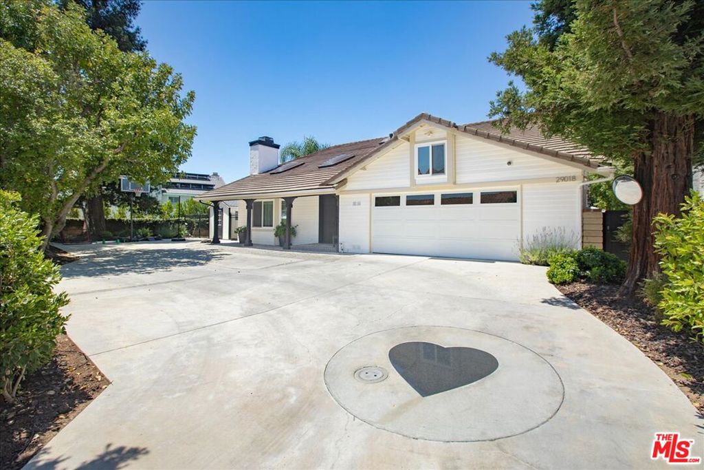Welcome to 29018 Saddlebrook Drive in Agoura Hills, a quintessential Cape Cod retreat that blends sophistication with relaxed charm. Boasting 3,163 square feet of well-designed living space on an expansive 11,839 square foot flag lot, this home is a rare find in the desirable Morrison East Meadows neighborhood. This property is located within the coveted Las Virgenes Unified School District. Step inside to discover a thoughtful layout featuring five spacious bedrooms and three elegant bathrooms. The formal dining room and living spaces are complemented by updated flooring and plantation shutters throughout, creating a seamless flow for entertaining and everyday living. Culinary enthusiasts will delight in the updated kitchen, equipped with high-end appliances and custom built-ins, while the media/recreation room and playroom offer versatile spaces for leisure.The primary suite is a tranquil haven, featuring a sitting area and private balcony with enchanting views. It also boasts a laundry area. Outdoors, enjoy the serene setting with a saltwater pool, spa, and built-in BBQ ideal for gatherings. Citrus trees including orange, lime, lemon, and pomegranate grace the landscape, adding to the home's unique charm.Modern updates include a newer roof and insulation, tankless water heater, internet wiring, and newer main water and sewage lines. With two laundry rooms, three fireplaces, an electric gate, Tesla 240w charger outside of garage, and ample garage and driveway space, this home combines luxury with practicality, offering an unparalleled lifestyle in Agoura Hills.