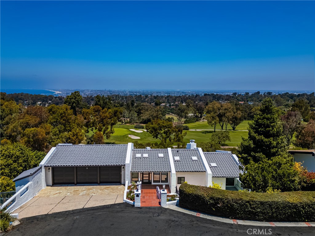 Tucked away on a quiet cul-de-sac and directly across from the prestigious Palos Verdes Golf Club, this beautifully updated home sits on an expansive 20,000+ square foot lot and offers commanding views of both the golf course and the Pacific Ocean from six private balconies. Bordering Malaga Cove / Palos Verdes Estates, the home boasts nearly 3,900 square feet of living space.
The property features a reverse floorplan that places the main living areas and primary suite on the upper level, perfect for enjoying the sweeping views, while the majority of the bedrooms are privately tucked below. Both levels offer a light filled layout with brand new LaCantina win-doors and windows that bring the outdoors in. The spacious living room, formal dining area, and open kitchen flow effortlessly to expansive view decks, ideal for entertaining. The kitchen is equipped with matte white Café appliances that combine high end design with professional grade performance. The upstairs primary suite features a fireplace, walk-in closet, and its own private balcony. A guest powder room completes the upper level
Downstairs, the home includes a second primary suite, ideal for guests or multigenerational living, plus two additional bedrooms that share a full bathroom. A large family and game room with a fireplace and built-in bar anchors the lower level, along with a dedicated laundry room and generous storage space perfect for a wine cellar or additional use.
This home has been extensively upgraded throughout, including all new PEX plumbing, complete electrical rewiring, dual zone HVAC with two new heaters, two air conditioning units, all new ducting, and designer air registers. A tankless gas water heater, new Toto bidet toilets, Brizo plumbing fixtures, and a Generac backup generator add comfort and convenience throughout. All renovations and upgrades were completed with proper city permits and approvals, ensuring quality, safety, and long term peace of mind.
The finished three car garage features vaulted ceilings, recessed lighting, and space for a car lift, while the wide driveway provides ample additional parking. The landscaped backyard includes mature fruit trees and space for a future garden or retreat.
With thoughtful updates, panoramic views, and a prime location, 5 Yellow Brick Road offers a rare opportunity to enjoy refined coastal living with comfort, style, and room to grow.