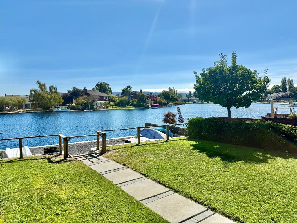 Sophisticated and airy end-unit waterfront townhome with a private dock on an extra-large lot. Sparkling water views fill the kitchen, living room, and two upstairs bedrooms, creating a serene backdrop for everyday living. Thoughtfully updated with designer touches, curated colors, and wood-style flooring throughout, this two-story residence offers 3 bedrooms and 2 full baths, with one bedroom and a full bath located on the main level. A custom fireplace anchors the living space, which opens to a spacious patio and lawn for seamless indoor-outdoor entertainment. Community amenities include two pools, a jacuzzi/spa, tennis courts, a clubhouse, and access to Foster City's scenic bay trails. A rare opportunity to enjoy true waterfront living with modern style and comfort.