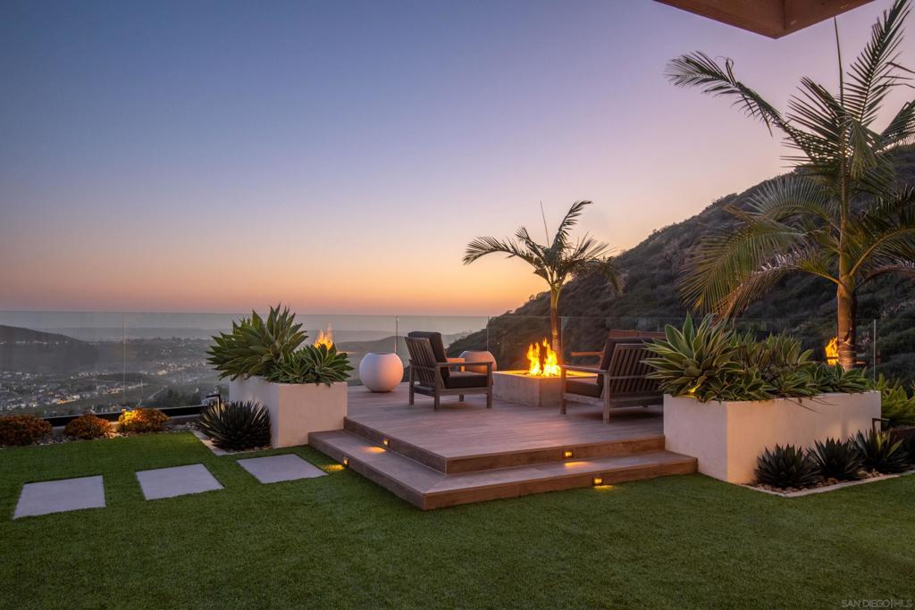 Perched on a rare ocean-view lot in the renowned Westcliffe Community of San Elijo Hills, this 4,600 sq. ft. estate—with a detached casita —offers unmatched privacy with no immediate neighbors and sweeping ocean views from every room of the house. The owners recently completed an extensive backyard transformation, featuring a custom fire pit, over 100 feet of frameless glass railings, custom landscape lighting, drip irrigation system, succulent-filled planter boxes, a lighted trellis, and a full outdoor kitchen equipped with two refrigerators, custom draft beer station, built-in BBQ, pizza oven, outdoor TV, and porcelain countertops and tile. Every detail was thoughtfully designed to highlight the breathtaking Pacific views from this elevated and private yard perfect for entertaining. Step inside through a custom iron front door into a grand entry with soaring ceilings and an entry garden. The main living room opens completely to the backyard through La Cantina doors and features a custom cabinetry entertainment center. The open floor plan includes 2 bedrooms on the main level with the option of using one as an office, an expanded kitchen with Viking stainless appliances, and a dedicated coffee bar. The casita has been expanded to 500 sq ft of living space including one bedroom, kitchen, living area, and full bath with a washer and dryer. Upstairs, you'll find four bedrooms; three generously sized guest bedrooms—each with its own en-suite bath—alongside a spacious loft area, perfect for a game room, media space, or cozy lounge.