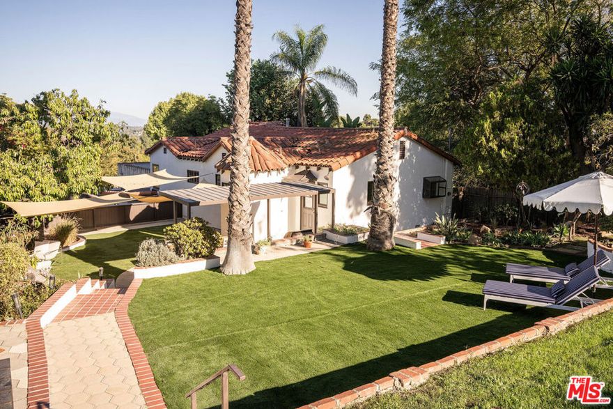 Welcome home to the definition of an oasis within the city, a serene escape perched in the scenic hills of Mount Washington, where tranquility abounds and city life feels worlds away. This character rich Spanish with three bedrooms, two baths and two added office/den spaces is the unique retreat you have been waiting for. Tucked along a quiet street, and nestled up a private drive, surrounded by dramatic canyon terrain, lush greenery, and privacy at every turn. Follow the charming tile steps upward and be greeted by a secluded front porch, an intimate cozy spot perfect for sipping your morning coffee, or unwinding with a good book as treetop breezes roll by. Open the large wooden door to reveal an expansive living room with rich hardwood floors throughout, warm natural light, beam ceilings and peekaboo views of the mountains, where you can nestle up to your handsome fireplace, relax and chill. An elegant formal dining room provides the ideal spot for entertaining, hosting parties, and gatherings with loved ones. The large kitchen is designed to inspire the chef in you, featuring floor-to-ceiling custom cabinetry, pantry storage, stainless steel appliances, custom built oven hood, separate wash/dryer area, and a charming breakfast nook. Step outside off of the backdoor door where a magical, massive, sprawling world awaits situated on a double lot spanning over 15,000 sqft with lush grounds and panoramic views. The oversized lots also ensure exceptional separation and a sense of peaceful seclusion. Multiple decks and patios with mature landscaping, and generous grassy spaces offer endless possibilities: BBQ and enjoy al-fesco dining under the stars, build a play area on the lawn, create your dream garden or use the space however your heart desires. Detached electrified bonus structure in the upper yard, offers added value, making for a home office, home gym or creative studio. The Zen-like atmosphere continues frontside, where a grassy section is perfect for meditation, swing sets, play areas, and endless park-like yard possibilities. Two upper level bedrooms offer comfort, large closets and practicality; the primary featuring its own suite, with an additional bedroom and office on the first level. Downstairs library/office is wonderfully cozy with glass-enclosed bookshelves and a gorgeous fireplace with colorful inlaid stones. Attached 2 car garage offers additional space and storage with professional grade shelves and cabinets. Close proximity to all the best of Highland Park, Eagle Rock, Silver Lake, and DTLA where cafes, eateries, parks, and hiking trails are within easy reach. Located within Mount Washington Elementary. Soulful, private, nature-woven, and filled with light at every turn, Oneonta is more than a home... it's a lifestyle.