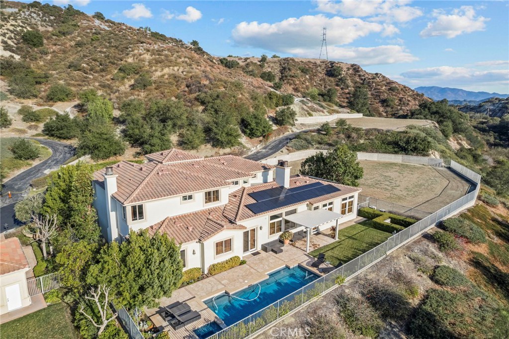 YOU DON'T WANT TO MISS THIS ONE!!! Nestled within the privately gated Falcon View Estates—one of Orange County’s best-kept secrets—this stunning 5,903 sqft. custom estate sits a top a 13,680 sqft. cul-de-sac lot, offering unparalleled privacy, luxury, and breathtaking mountain views. As one of only six custom-built homes in this secluded 42-acre enclave, this residence exudes exclusivity and sophistication. Designed for both grand entertaining and everyday elegance, this six-bedroom, seven-bathroom estate showcases meticulously curated upgrades. The expansive chef’s kitchen seamlessly opens into a high-ceilinged family and dining room, where panoramic views of the pool and rolling hills create an idyllic backdrop. The gorgeous downstairs primary suite serves as a private retreat, featuring a mahogany fireplace, direct backyard and pool access, two spacious closets, and a spa-like master bath. Upstairs, an expansive media room is designed for ultimate entertainment, complete with a custom cherry and quartz bar, a kitchenette, and French doors leading to a covered balcony with stunning hillside vistas. This home is equipped with an array of impressive upgrades, including a four-car attached garage (882 sq. ft.) with sectional steel doors and a durable epoxy-finished floor. Recent enhancements include a fully paid solar system, fresh interior and exterior paint, new pebble-tech pool resurfacing with a high-efficiency heater, custom wood shutters throughout, updated bathrooms with new quartz counters and toilets, and brand-new hardwood flooring spanning both levels. Beyond its luxurious interior, the home offers direct access to Whiting Ranch Regional Park and Cleveland National Forest, providing endless opportunities for hiking, mountain biking, and equestrian adventures. Situated in a rare, low-density development, this estate ensures lasting exclusivity while maintaining convenient access to State Route 241, just eight minutes away, allowing for seamless connectivity to central and south Orange County. This is a rare opportunity to own a meticulously upgraded estate in one of the region’s most serene and sought-after communities. A true must-see for those seeking the perfect blend of luxury, privacy, and nature.