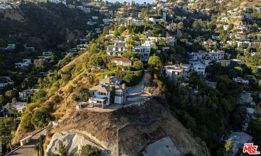 One of greatest promontory lots in the Hollywood Hills offering unobstructed 270-degree views. Located at the end of a cul-de-sac above the Sunset Strip, this rare property offers approximately 1 acre of land with panoramic views stretching from downtown Los Angeles to the Pacific Ocean. The existing residence is approached by a gated long driveway leading to an expansive motor court, creating a true sense of arrival and privacy. An exceptional opportunity to either remodel the existing home or build new. The property includes almost approved plans by incredible design studio "Woods + Dangaran" for a 9,654-square-foot home designed to maximize the site's dramatic scale, natural light, and sweeping panoramic vistas. A rare offering in one of Los Angeles' most coveted hilltop locations.