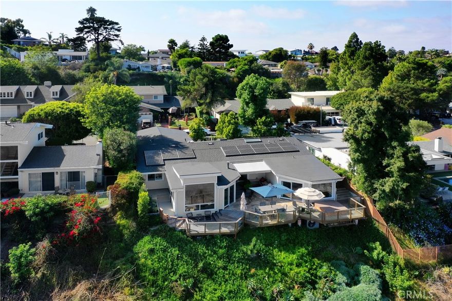 Discover this beautifully remodeled single-level home, perfectly positioned on one of the most desirable and quiet cul-de-sacs in the coveted Top of the World neighborhood. From its elevated perch, enjoy sweeping panoramic views spanning the Saddleback Valley to San Diego County, with a touch of ocean in the distance—the sparkling evening lights are truly breathtaking. The residence offers 3 bedrooms, an office with a closet (which could be a 4th bedroom) and three bathrooms. An airy, open floor plan with soaring ceilings creates a sense of volume and flow, anchored by a gourmet chef’s kitchen with LG and Wolf appliances, a spacious center island, and a built-in breakfast bar. Rich old-growth Hickory wood floors and custom Walnut cabinetry are complemented by thoughtfully placed skylights, filling the home with warmth and natural light. Outdoor living is effortless, with expansive deck space designed for entertaining and relaxation—complete with a barbecue area, al fresco dining, and a private spa overlooking a pristine natural canyon and those stunning views. Additional highlights include a walk-in pantry, air conditioning, a dedicated laundry room, a beautifully appointed two-car garage with EV charging, and a solar system for efficiency. Close to award-winning schools and parks, this property embodies the best of the Laguna Beach lifestyle.