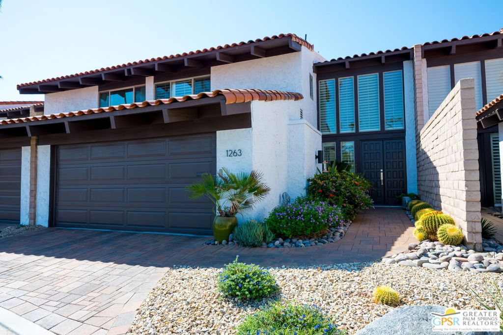 A unique opportunity to own a residence in the highly desirable DeepWell Ranch community. This unit is one of only 8 two story town homes built in the guard gated access controlled development designed by renowned architect Barry Burkus. This home offers a highly upgraded interior with a chef's kitchen and all Viking appliances, wood beamed ceilings and a soaring two story glass wall in the dining area. The large living room offers a stone faced fireplace and views over the rear patio and common area. Also downstairs is a bedroom/den with an en-suite bathroom. Up the dramatic curving staircase to the second level are two additional large primary suites each with en-suite bathrooms. They are connected by a dramatic open walkway looking down to the first floor. The view to the mountains from both of these rooms are breathtaking. This spectacular unit looks over the manicured common area and is situated steps from one of the 3 community pools and spas. There is also a newly refurbished sports count within the complex. Remember, you own the land in peaceful and quiet south end of Palm Springs.