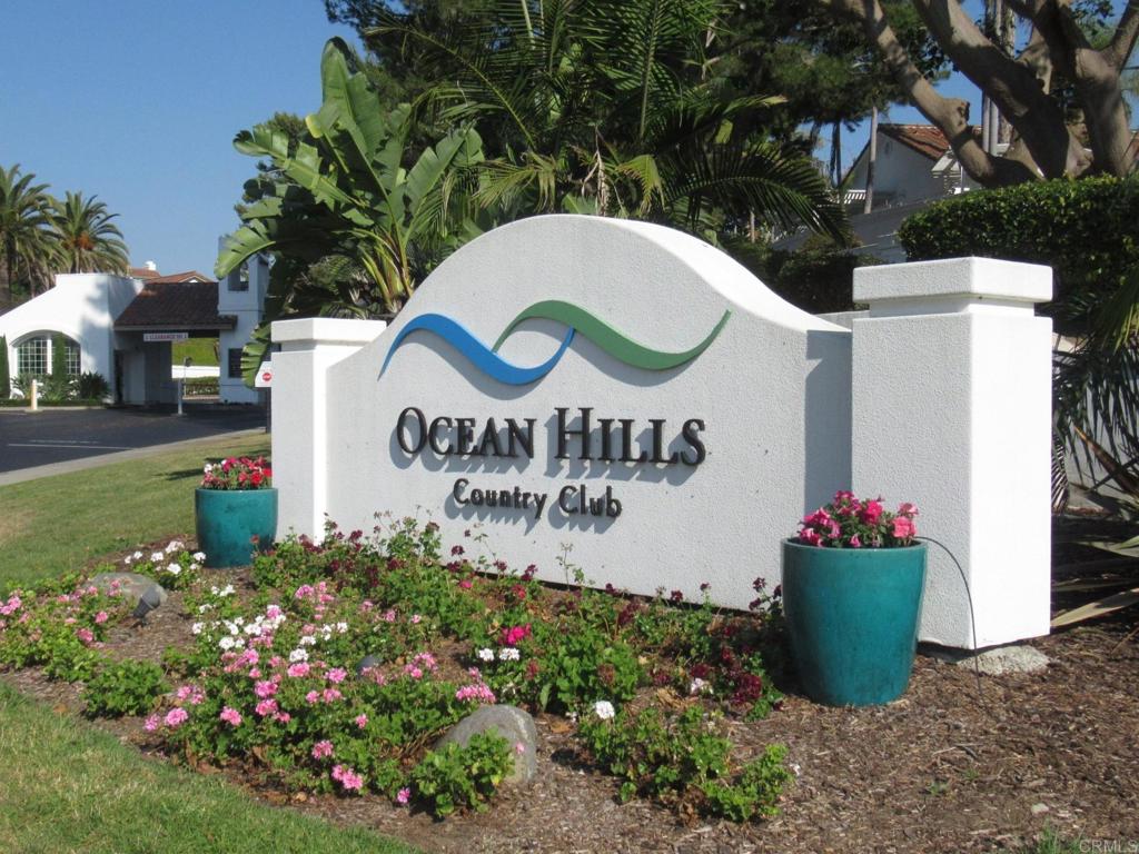 1-story "Athena" floor plan in the 55+ paradise that is Ocean Hills Country Club, a gated community in southeast Oceanside. A short walk to the clubhouse, where residents can enjoy golf, tennis, pickle ball, swimming, and a large clubhouse with an auditorium, a library, billiards, exercise rooms, and rooms for various activities. Laminate flooring in living room, dining room, and kitchen. New carpet in bedrooms. New shower in primary bathroom. Carport converted to a 2nd 1-car garage. Backyard with patio table.