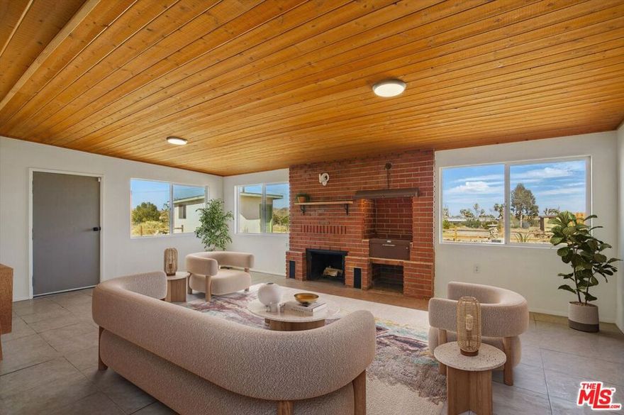 ATTN: Owner Users Investors.Nestled just minutes away from vibrant Joshua Tree village and breathtaking National Park, this midcentury ranch compound is a rare find! With two separate houses , separate driveways, several outbuildings, it's perfect for someone looking to invest or create a relaxed live/work retreat. set on a generous 1.25-acre lot, plus an extra 1.25 acres of fenced land with power, valued at $80k. you've got plenty of room to build or just soak up the natural beauty.The main house is flooded with natural light, offering a spacious open floor plan with two cozy living areas, each with its own wood burning fireplace. One even has a spit BBQ. The kitchen is a cook's dream with stainless steel appliances, new butcher block countertops, and a chefs sink. You'll find tons of built-in storage, a fully equipped laundry room, and over 1,900 square feet of living space. There's also an extra 650-square-foot suite that's ideal for a main bedroom, art studio, or guest area, featuring its own entrance, large walk-in closet, and a beautifully remodeled bathroom. You've got all the comforts covered with natural gas for cooking and heating, radiant electric heating, and fireplaces for winter, plus evaporative cooling and AC for the summer months. Enjoy outdoor living with two patios, a lovely shaded front yard and a pergola in the backyard for entertaining.The second house is a charming 1,000-square-foot space with two bedrooms, a remodeled bathroom, and a modern eat-in kitchen with access to a private backyard. It's tucked away from the street and includes an oversized one-car garage, making it a perfect rental unit.The outbuildings are ideal for storage or creative projects; one cabin even comes with electricity and an underground wine cellar. The entire 1.25 acres is fenced with multiple gates and has two driveways, including one that leads to the backyard and RV parking. There's also a large concrete slab ready for new possibilities like a garage or horse stables. Plus, it's a horse-friendly property and includes its own water well for irrigation, which is a rare find in town. . Each house has separate meters, privacy fencing, and individual driveways and parking areas, making it convenient if you want to rent them out.It's not common to come across a property in Joshua Tree/Yucca Valley with such original character and features. This place is packed with potential for you to make it your own or simply enjoy everything it already offers.