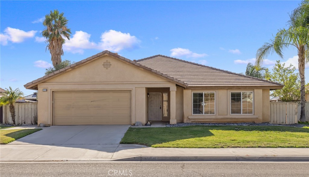 This turnkey 3-bed, 2-bath single-family home is situated on a large 7,405 sq foot lot and features 1,570 sq ft of living space. Built in 2003, this single-level home has a convenient open-concept floorplan with a large living room with cozy fireplace and adjacent dining area. The kitchen with a breakfast bar, opens to both the dining & living areas. Down the main hallway are 3 bedrooms, including a primary suite and 2 full bathrooms. The primary suite with attached bathroom, includes a walk-in closet, dual-sink vanity, and sliding doors to the rear patio/yard. The home features new carpets throughout, central HVAC system, and an attached, direct-access 2-car garage. The exterior of the property includes a spacious front yard with driveway parking in addition to the 2-car garage, gated/fenced rear yard with a covered patio and expansive yard. Additional benefits include solar panels, convenient location just blocks from both the elementary & middle schools, and added privacy with no rear neighbors. Do not miss this amazing opportunity!