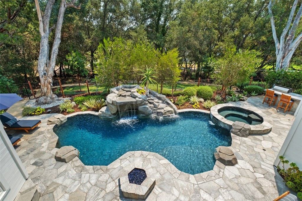Located in the desirable Village community of Coto de Caza, this 4-bedroom, 2.5-bath home offers both charm and functionality in a peaceful, natural setting. The top level features a well-appointed kitchen, a dining room, and two separate family rooms with vaulted, beamed ceilings—each overlooking the beautifully landscaped backyard. The large primary bedroom overlooks the yard through several windows and connects to a spa-like ensuite bathroom complete with a walk-in shower and separate soaking tub.
Step outside to your own private oasis, where you’ll find a sparkling pool with cascading waterfall, spa, fire pit and a covered outdoor lounge designed for year-round enjoyment. The fully equipped outdoor kitchen includes a built-in BBQ, refrigerator, sink, and ample counter space—perfect for hosting gatherings or enjoying al fresco meals with family and friends. Multiple seating areas, lush landscaping, Sonos sound system and ambient lighting create a resort-like atmosphere ideal for both entertaining and relaxation. Beyond the private yard, an additional 2,000 square feet of open, grassy space along with a tranquil wooded backdrop—creates a seamless extension of the property. Owned by the HOA, this rare outdoor setting enhances the home’s sense of space, privacy, and natural beauty. Together, it offers the look and feel of a nearly 10,000 square foot lot—ideal for outdoor living, entertaining, and everyday enjoyment.
Enjoy all that Coto de Caza has to offer, including award-winning schools, a private golf and racquet club (membership required), equestrian trails, hiking and biking paths, sports parks, and more.