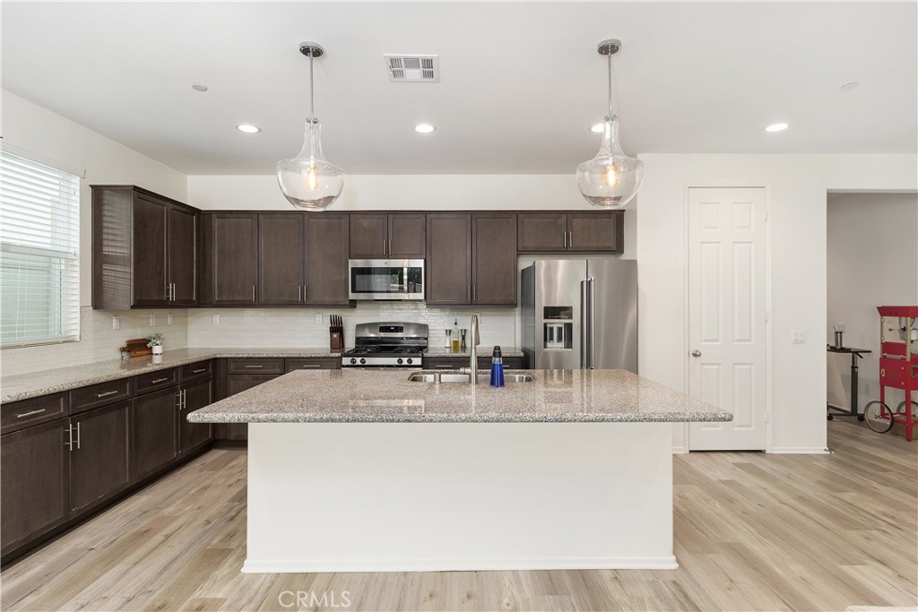 A fabulous single-family home in the sought-after Spencer's Crossing community! This stunning residence offers three spacious bedrooms plus a massive bonus room—perfect as an entertainment space, home office, or additional bedroom. The open-concept design seamlessly connects the living room, kitchen, and dining area, showcasing upgraded cabinetry and expert woodworking craftsmanship. Gorgeous laminate flooring complements the large island and well-appointed pantry. Designed for energy efficiency, the home features high-performance windows and doors, a whole-house QuietCool system, a tankless water heater, and upgraded LED lighting. Generously sized bedrooms include expansive walk-in closets for ample storage. Enjoy resort-style community amenities, including scenic walking trails, multiple pools, playgrounds, BBQ areas, and cozy fire pits. The backyard is an entertainer’s dream, with beautifully designed turf and pavers that create a stylish, low-maintenance outdoor space. Let your imagination run wild with endless possibilities!
