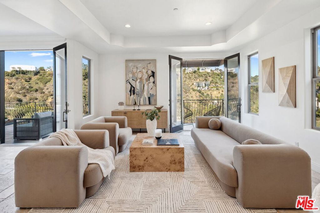 UNMATCHED VALUE IN THE HOLLYWOOD HILLS - PRIVATE GATED STREET WITH STUNNING VIEWS!  Welcome to 8031 Floral Ave! Nestled at the end of a private drive behind a secure gated entrance, this breathtaking residence offers unparalleled city and canyon views from every floor. Completed in 2013, the home boasts wrap-around terraces, soaring ceilings, and an open-concept design that seamlessly blends elegance with modern luxury. The main level features a grand living room with a cozy fireplace, an elegant dining area, and a chef's kitchen outfitted with granite countertops, custom cabinetry, and top-of-the-line appliances. Descending to the primary suite level, you'll find a serene retreat with its own fireplace, dual walk-in closets, and a spa-like primary bath with a soaking tub and walk-in shower. This level also includes a spacious bonus room. The lower level offers two additional bedrooms, each with en suite baths, providing comfort and privacy for guests or family members. Experience luxury, privacy, and breathtaking views in this exceptional home.