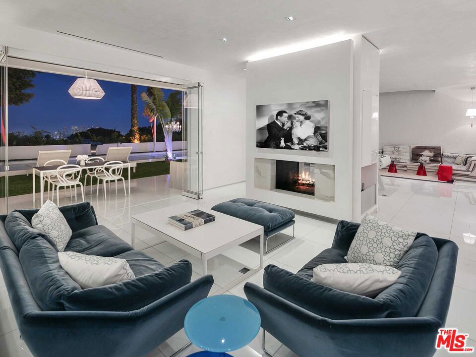 This newly remodeled & exceptionally private Trousdale Estates residence is located above the hills w/180-degree city/ocean views & a one-of-a-kind contemporary, open floor plan. Thoughtfully designed & overlooking city lights, this 5 bed/5.5 bath estate gleams w/modernity & features all the amenities of an entertainer's home; with a striking, enclosed entry showcasing floor-to-ceiling glass, multiple outdoor lounge areas surrounded by beautiful landscaping & outdoor bonus room ideal for a gym/office. With quartz floors, mosaic glass detailing, Venetian plaster, skylights, & custom-cut Italian doors - this home was designed w/the finest attention to detail, including the most elevated of amenities including a spa/sauna & steam room. The immaculate interiors beam with natural light & include an elevated formal dining room, expansive living/family area with double-sided fireplace & a seamless chef's kitchen w/adjacent service kitchen - all connecting to the spacious backyard pool/spa.