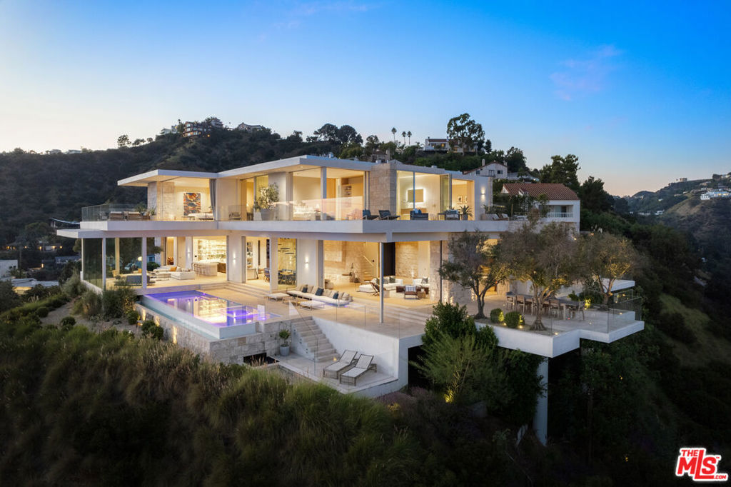 Discover the pinnacle of contemporary luxury living at 8201 Bellgave Place, a newly constructed masterpiece completed in 2022. This architectural gem was meticulously crafted by renowned luxury developer Clive Robertson and designed by SAOTA, the globally acclaimed architectural firm. Nestled adjacent to the iconic Pierre Koenig's Stahl House, this home is perched on the final promontory of the legendary Sunset Strip, offering a once-in-a-lifetime opportunity to own the best vantage point in Los Angeles.With a vast 9,052-square-foot floor plan and a lot size of 23,307 square feet, this residence is a world all its own. Imported Italian split-face travertine adorns both the exterior and interior. Find four ensuite bedrooms all thoughtfully situated on the upper floor and two additional well-appointed powder rooms. The presence of an office space and a stylish bara true showstopperall speak to the lifestyle of modern sophistication. Outside, find an infinity pool with a built-in spa and expansive outdoor dining spaces. The property is beautifully landscaped with mature olive trees, providing elevated natural beauty that complements the sleek contemporary design.Of course, the panoramic views take the spotlight, stretching 270 degrees. Enjoy stunning vistas from Griffith Observatory to Downtown, Century City, and all the way to the Pacific Ocean. Don't miss your chance to own this architectural marvel in the most coveted location in Los Angeles.
