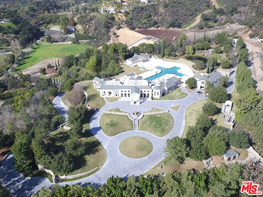 MAJOR PRICE REDUCTION  PRICED TO SELL. This grand estate is situated on a promontory with supreme city and ocean views and lies behind the guarded gates of the exclusive and famous Bradbury Estates community. This one-of-a-kind, almost 35,000 SQFT residence boasts a massive main house comprised of 2 master suites, 5 guest suites, Chef's kitchen and a 2-story library. The property has every amenity one could want; an enormous and spectacular infinity-edge pool, 15-person spa, guesthouse, 10-car garage, pool house, 3-D theater, 2,000 bottle wine cellar, poker lounge, temperature-controlled trout pond with 2-story waterfall, subterranean firing range, 6 fireplaces, oak paneled elevator, & 600-foot entry drive. Exquisite details completed by expert craftsmen include French limestone exterior finishes, vaulted 40-foot ceilings, Venetian plaster and domes with hand painted frescos. The estate is simply breathtaking!