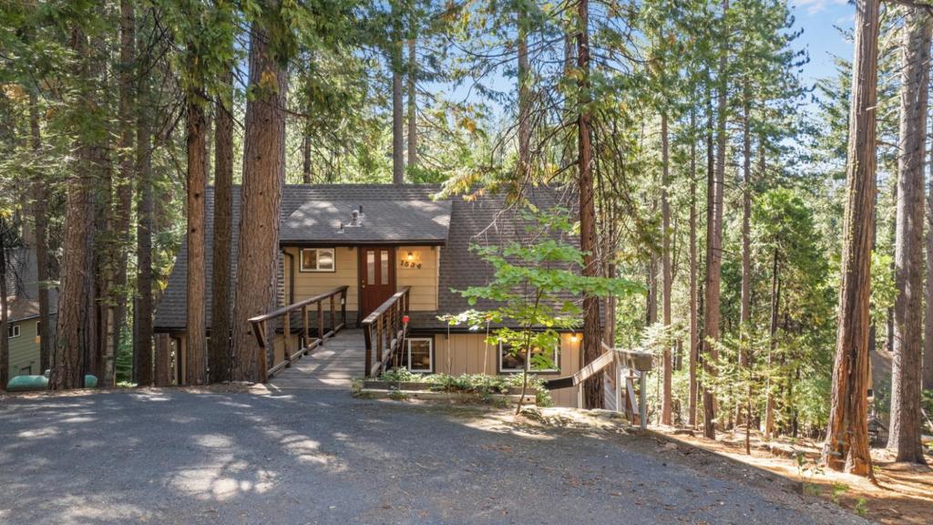 Escape to your mountain getaway where serenity and charm await you. This cherished cabin, affectionately cared for by its current owner for over 30 years, offers the perfect retreat amidst the natural beauty of the outdoors. Boasting 3 bedrooms and 2 baths with most furnishings included, approximately 1555 square feet, this cabin welcomes you with open arms. Discover the versatile additional sleeping or flex space, which can easily transform into a recreational room, catering to your every need. A cozy loft area invites you to unwind with a captivating book. Step into the heart of the cabin, where the living area beckons with its rustic charm, characterized by beamed ceilings and a warm wood-burning stove that exudes coziness. The large windows frame expansive views of the enchanting woods, blending indoor comfort with the outdoors. The kitchen, adorned with maple cabinetry and Corian countertops, stands as a testament to both form and function. Nestled on a .37-acre lot.
