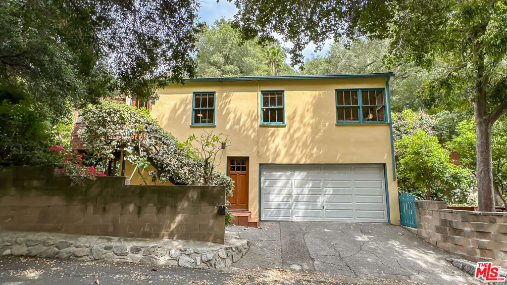 Right above downtown Burbank in the Verdugo foothills, Country Club Drive is the valley's version of Topanga Canyon, a charming, tree-lined country road known for its eclectic architecture and proximity to hiking trails. This classic California home built in 1940 offers the best of both city and country, tucked away in its own citrus orchard and surrounded by natural beautyand still within walking distance of stores, restaurants, a golf course, and the Wildwood and Stough nature centers. Included with the house are two adjoining lots that expand your sense of space and privacy. One lot offers 3,276 sq ft of lush, terraced landscape dotted with mature orange trees, the perfect setting for a tranquil garden or a quiet meditation spot. The second lot spans 5,610 sq ft and provides access to private hiking trails for nature lovers seeking adventure just outside their door.Perched high amongst the trees, this charming 2-bedroom, 1-bath home includes a flexible bonus room, for a total square footage of 1,102 sq ft. There is also a screened-in porch that blurs the line between indoors and out. Enjoy sweeping greenbelt views and the feeling of living in your very own private treetop sanctuary. The home features three distinct outdoor living areas, thoughtfully designed for relaxing, entertaining, or soaking in the peaceful canyon surroundings. This historic neighborhood was originally developed in 1921 as a country club and golf course, and its homes offer a rare blend of natural beauty, architectural charm, and local history. Here, you'll find the perfect balance of peaceful seclusion and easy access to the vibrant energy of the city. Whether you're savoring a quiet morning on the porch or exploring semi-private trails, this is a place where comfort, character, and nature converge. Welcome to your one-of-a-kind canyon retreat!