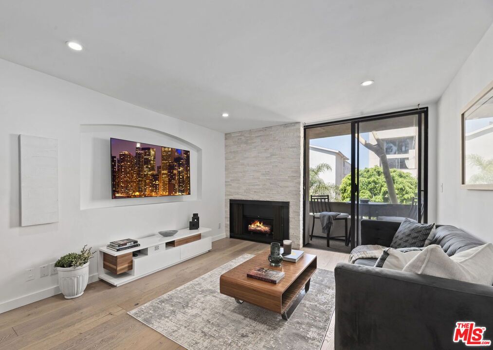 Located in the most desirable pocket of West Hollywood, this beautifully renovated 1-bedroom, 1-bathroom condo seamlessly combines modern luxury with everyday comfort.Flooded with natural light, the open living space features a cozy fireplace, and private balcony. The sleek, contemporary kitchen includes a large breakfast bar and porcelain countertops with elegant waterfall edges, all flowing effortlessly into the main living area. Additional highlights include wide-plank hardwood floors, a spacious walk-in closet, side-by-side in-unit washer and dryer, and central heating and air. The unit also comes with two assigned parking spaces and ample guest parking. Set in a secure, amenity-rich building, residents enjoy access to a rooftop lounge with panoramic city skyline views, a hot tub, sauna, billiards room, and a fully equipped gym. With a coveted street-facing location and steps from Melrose Place, this turnkey home offers the best of West Hollywood living. Seller is a Licensed real estate agent.