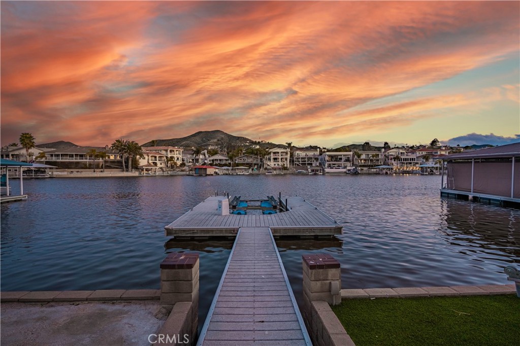 Waterfront "Paradise on East Bay Channel" in Canyon Lake. Enjoy this stunning waterfront location and views!!! Perfectly situated on a prime lot with 70 ft of frontage. You will experience breathtaking views of the mountains, boating, and wild life. Newly remodeled kitchen boasts granite counter tops, new cook top, dishwasher, newer wine fridge and a walk in pantry. Step thru the double door entry and take in the panoramic water views. The spacious great room features vaulted ceilings, crown molding, and tile thru out. A cozy wood burning fireplace in the family room with lots of natural sunlight coming thru the windows. Step outside to an expansive 800 sq ft deck with glass railing, seamlessly blending indoor and outdoor living. New ceiling fans on deck and in primary bedroom. The primary bedroom features shutters letting natural lite filter in along with a beautifully tiled walk in shower. A stylish vanity provides ample space and storage for daily use. This home is designed for both relaxation and entertainment featuring a private U-Dock with lift, allowing you to cruise the lake at a moments notice. Sea wall and terraced yard. The low maintenance yard ensures you have more time to enjoy the waterfront lifestyle. Additional upgrades include a new HVAC system, Professional Landscaping with Palm trees, and fresh paint. Whether you're hosting guests on your deck, enjoying lake views from your large windows, or out on the boat, this home delivers the ultimate lake experience. Flat driveway to park your boat or toys. Close to pickle ball courts, private lake for skiing and 18 hole SGA golf course.