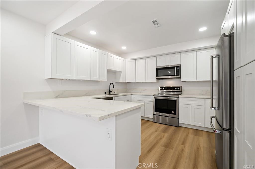 Must See - fully renovated ground floor condo with 2 car gated subterranean parking! LVP flooring throughout, tall baseboards and LED lighting. Updated kitchen with white shaker cabinets, quartz counters and featuring high end KitchenAid appliances, including fridge. The kitchen peninsula offers bar stool seating and opens to the family room. Off the family room is a slider to the private patio with street access, one of the few units with direct access. A large laundry room includes washer and dryer. The hall bathroom features a deep tub and is across from the large guest bedroom. The master bedroom is also a great size and has two closets and an area that could be used as a small home office or study area. The master bathroom features an updated vanity, sink, mirror and a walk in shower. Nearly everything in this property has been upgraded. Convenient location, walking distance to Hillcrest Park, Fullerton High School and Fullerton College and only a short drive to downtown Fullerton and Cal State Fullerton. This property is ideally located for easy access to the 91 & 57 freeways and is just minutes away from all the amazing amenities offered in Orange County!