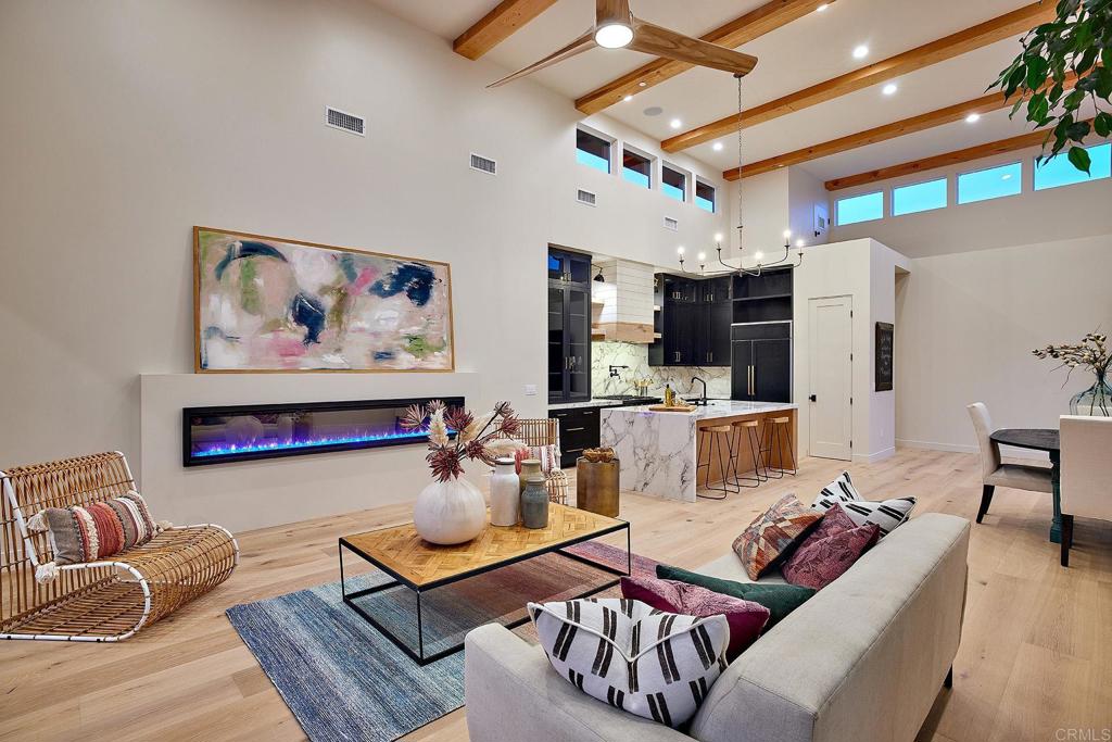 RARE SINGLE LEVEL HOME JUST BLOCKS FROM THE BEACH. Located in close proximity to Moonlight Beach, in walking distance to the shops, restaurants and nightlife options in downtown Encinitas, this elegant, recently built custom home is the opportunity of a lifetime. Built in 2021, the home offers a designer-quality interior with modern finishes, wide plank wood floors and an ADU with riveting ocean views. An electric gated entry allows for privacy, while a well-conceived interior/exterior plan takes full advantage of the spacious lot, with large outdoor living areas that have been designed for entertaining and relaxation. In the open concept living room/kitchen and dining area, a wall of retractable glass doors connect to a completely private, partially covered patio with a custom water feature and custom lighting. Two story ceilings with exposed beams and clerestory windows bring light into the living room, where an integrated electric fireplace creates a modern aesthetic. Showcasing the latest technology and style, the kitchen has furniture-grade wood cabinets, stone counters, a center island with a waterfall edge, a built-in refrigerator, and a gas range with pasta filler. With glass doors that open to the patio, a retreat with a fireplace and volume ceilings, the primary suite may be difficult to leave. The spa-like bath is equally appealing, as it has stylish designer tile, a freestanding tub, dual vanities and a walk-in shower. An office and two large secondary bedrooms with sophisticated en suite bathrooms complete the floor plan of this single level home. The upstairs ADU has a modern kitchenette, a separate exterior entry, a full bath, vaulted ceilings, and retractable glass doors showcasing gorgeous ocean/sunset views. Other highlights include a convenient half bath/mud room and laundry room off the attached two car garage, built in speakers, a spa, owned solar panels, a Tesla power wall, low maintenance landscaping, fire sprinklers, LED lighting, and an advanced HVAC system. Set a short distance away from the train station and the best that Encinitas has to offer, this refined turnkey home offers a lifestyle that many can only dream about.