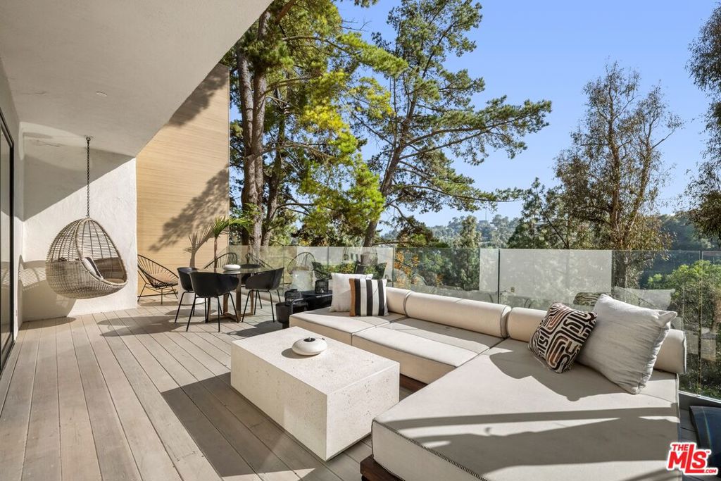 Perched at the end of a serene cul-de-sac in the Hollywood Hills, this impeccably renovated three-bedroom, two-bathroom residence presents an extraordinary opportunity to experience refined living in one of Los Angeles's most sought-after enclaves. Elevated at tree level above the canyon, the home offers panoramic, unobstructed views and a profound sense of privacy just moments from the Westside, the Valley, esteemed Wonderland Elementary, and the Mulholland Tennis Club. A private, gated courtyard sets a tranquil tone as you enter into a light-filled, open-concept interior where sophisticated design meets timeless elegance. White oak hardwood floors flow throughout the main level, which is wrapped in floor-to-ceiling canyon vistas. The custom chef's kitchen is a statement in style and functionality, outfitted with sleek quartz countertops, designer cabinetry, and premium, integrated appliances. On the main level, a spacious guest bedroom enjoys courtyard views and access to a beautifully appointed bath. The lower-level primary suite is a private sanctuary, featuring a deck, an expansive walk-in closet, and a spa-caliber bath that rivals the world's finest resorts. An additional flex space with custom European-style built-ins offers versatility for use as a den, office, or additional bedroom crafted with both comfort and aesthetic in mind. There is a direct access one-car garage, and also ample street parking on the lightly-trafficked cul-de-sac street. Whether enjoying coffee in the morning light, hosting a dinner party under the stars, or savoring a quiet moment in the Japanese-inspired Zen garden, this home offers the perfect balance of privacy, nature, and city convenience.