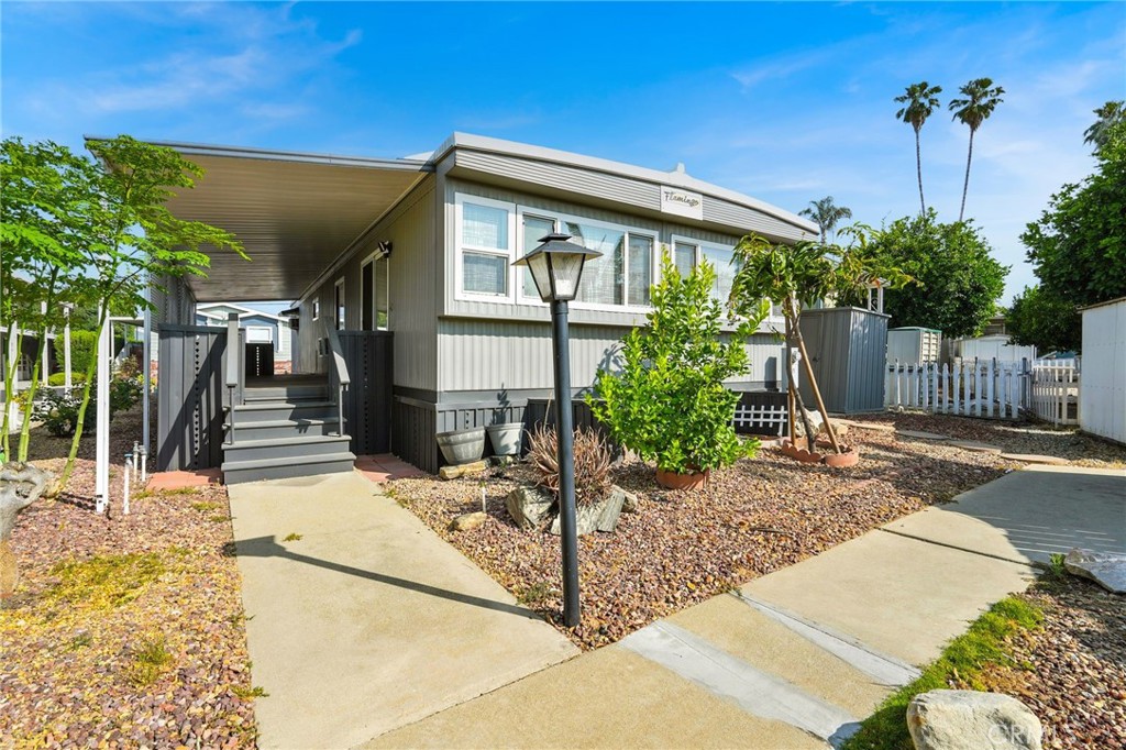 Turn-Key 2 Bed, 2 Bath Home in All-Age La Verne Kings Way Garden Mobile Home Park — Pool, Playground & Pet-Friendly! Why rent when you can own this move-in-ready manufactured home? Featuring an open floor plan, laminate wood flooring, and ceiling fans. The kitchen includes ample cabinets and a dining area with a built-in hutch. The spacious primary Master Bedroom offers a recently remodeled walk-in shower. Both bedrooms are generously sized, with decent closet space. Enjoy outdoor living with a shaded front porch, low-maintenance landscaping, and a storage shed. The long-covered driveway fits 2-3 vehicles. Located near top-rated Bonita schools, shopping, dining, and freeway access. Park approval required. Buyers are encouraged to verify all measurements, features, and finishes in person.