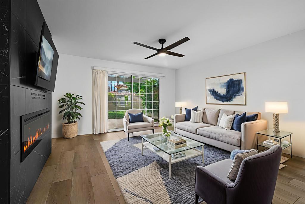 Short Term Rentals Allowed! Discover a stunning two-bedroom, two-bath condo in the heart of South Palm Springs, beautifully remodeled by a renowned desert designer. This sleek, modern space is like stepping into a brand-new home, featuring a fully updated kitchen with state-of-the-art Samsung appliances, newly renovated bathrooms, and a chic fireplace that adds warmth to the living room. The luxury vinyl flooring enhances the contemporary vibe throughout. Situated on the first floor with no steps, this private unit offers the convenience of its own washer and dryer located on the back patio, along with a secluded backyard area. Mesquite Country Club has a very liberal rental policy allowing stays of 7 days or more, it presents exciting income potential. Carport parking and you own the land. Just moments to Palm Canyon, you will enjoy proximity to the area's most sought-after shopping destinations, restaurants, nightlife, museums, and the lively Thursday night street fair. With exceptional design by Sandoval Designs, this property is a rare find!