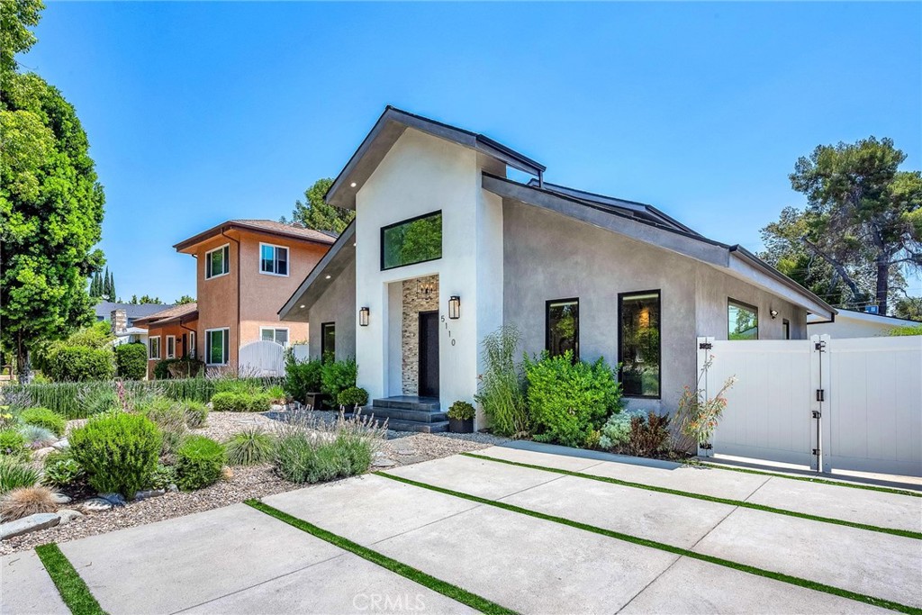 Welcome to this stylish and thoughtfully designed modern French farmhouse in the heart of Sherman Oaks. From the moment you arrive, the bold front entry—featuring a contemporary chandelier and stone accent wall—sets the tone for what’s inside.
Step into a bright, open two-story layout filled with natural light, wire-brushed Sahara oak floors, and custom designer touches throughout. The living and dining areas flow together seamlessly, highlighted by a striking stone wine wall and built-in ceiling speakers, perfect for entertaining.
The chef’s kitchen is equipped with custom cabinetry, quartz countertops, and a premium Thermador appliance package. The adjacent family room features a large fireplace with elegant stonework and custom built-ins on both sides.
Glass sliders open to a private backyard retreat with a built-in BBQ, sparkling pool and spa, and a fully equipped 2-bedroom, 1-bath guest house with its own kitchen, laundry, and separate address (5108 Greenbush Ave). Ideal for extended family, a guest suite, or rental income.
Upstairs, the junior suite includes a full bathroom and Juliet balcony overlooking the pool. The spacious primary suite offers its own Juliet balcony and a spa-like bath with soaking tub, oversized rain shower, and skylight. Two additional junior suites are located on the main level, each with their own en-suite bathrooms.
Smart features include built-in ceiling speakers (including patio), Ring doorbell, Ecobee smart thermostat, pre-wired WiFi/TV in every room, and a full alarm system. A gated front entry and elegant powder room add convenience and privacy.
Lush, Low-Maintenance Garden
Raised planter boxes with automatic irrigation overflow with tomatoes, herbs, and vegetables, while drought-resistant landscaping features charming South-of-France-style rocailles. Milkweed and flowering shrubs attract monarchs and hummingbirds, and a prolific lime tree and mature lemon tree provide fresh citrus year-round.
