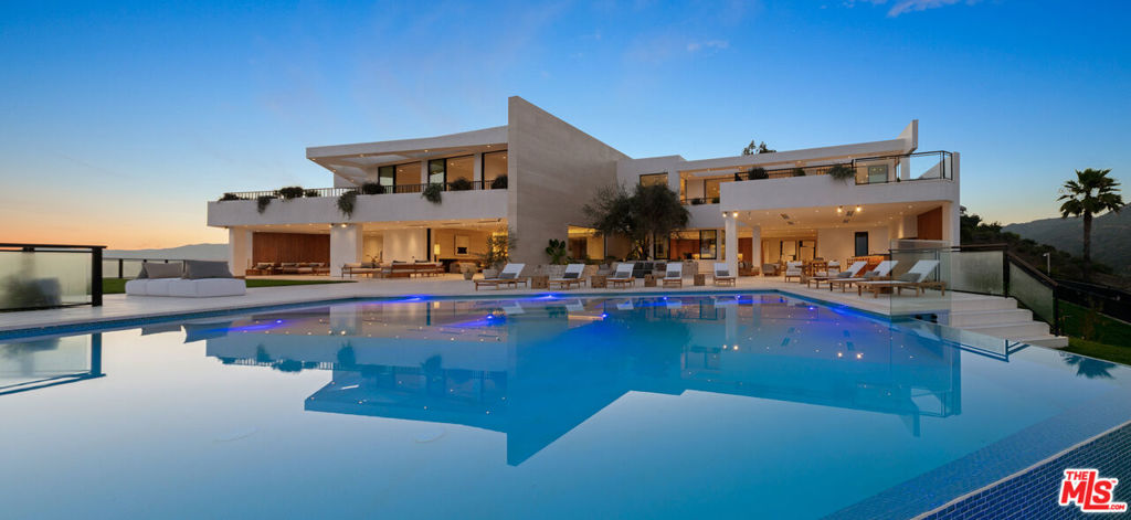 It's rare to find truly spectacular unobstructed, panoramic views paired with complete privacy, but you'll find both at The Outlook, a stunning new contemporary home designed by David Maman. Perched atop a private cul-de-sac high above Brentwood, 1204 Chickory Lane spans approximately 15,000 square feet with 9 bedrooms, 16 bathrooms, and breathtaking vistas that sweep from Downtown L.A. and the Getty Center to the Pacific Ocean and beyond. Here, you don't just see the city you rise above it.Tucked behind double gates, a long private driveway leads to the grand entrance with water feature. Inside, soaring ceilings and sleek pocket doors frame breathtaking vistas and effortless indoor-outdoor living.The main level flows to a resort-style backyard with an edgeless pool, outdoor kitchen, covered patio, and expansive grassy lawn. Interior highlights include formal living and dining rooms, a private office, and a stylish open kitchen with adjoining family area, butler's kitchen, walk-in pantry, and commercial-grade fridge.Upstairs are 5 en-suite bedrooms, including a luxurious primary suite with dual bathrooms, dual walk-in closets, and an oversized private view patio. Each bedroom enjoys sweeping canyon and ocean views. The amenity-rich lower level offers a bar, pool table, temperature controlled glass wine cellar, screening lounge, and a full wellness center with gym, sauna, steam, cold plunge, hot tub, and massage area. Two ensuite bedrooms provide additional space for guests.Additional features include an 8-car gallery garage with guard room, 2-bedroom staff suite, and dual laundry rooms.Moments from Brentwood's top shops and dining, 1204 Chickory Lane is where privacy meets elevated luxury.