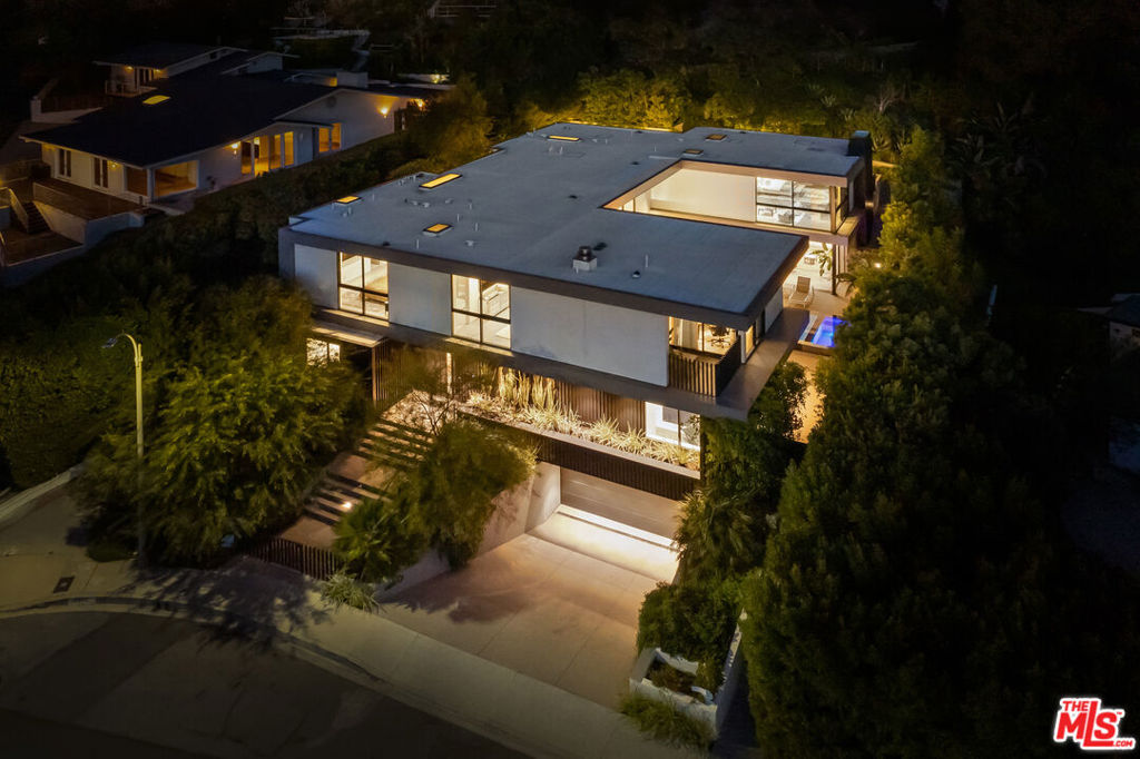 Exceptional opportunity to possess a contemporary masterpiece nestled in the prestigious Bird Streets of the Hollywood Hills. Situated at the top of the Doheny Estates, this architectural gem boasts 5 bedrooms and 8 bathrooms spread across ~7,800 square feet, commanding panoramic views of the Los Angeles skyline. The main floor is a symphony of design, featuring a bespoke zero-edge pool, outdoor living spaces embraced by floor-to-ceiling glass sliding doors, seamlessly melding the indoor and outdoor realms. Perfect for entertaining, the formal living and dining areas, complemented by a custom bar and glass wine vault, create an inviting ambiance. The kitchen effortlessly connects to an expansive family room, fostering an open and airy atmosphere. Ascending to the upper level, the Primary Suite exudes grace, offering a private retreat with a massage room, dual walk-in closets, and a personal outdoor sanctuary that capitalizes on the home's breathtaking views. Four additional ensuite bedrooms and a second living room complete the upper floor, ensuring luxurious accommodations for all. This residence goes beyond the ordinary with added features like a media room, fitness area, cutting-edge surround sound system, integrated smart home technology, and intricate designer touches that elevate it to the pinnacle of luxury. This distinguished Doheny Estates property represents an extraordinary value, providing both seclusion and convenient access to the Sunset Strip, West Hollywood, and Beverly Hills. Immerse yourself in the epitome of upscale living with this rare and unparalleled offering.