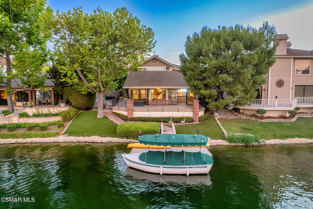 Extraordinary location and views on the MAIN Channel in guard gated Westlake Island. An absolute premier ''end of cul-de-sac'' location with some of the best views the island has to offer! This timeless traditional is something special offering up a sensational opportunity! Enter through a private gate to a wonderful large courtyard that includes a spa, professional landscape and views! Some of the many features of this estate include magnificent soaring cathedral beamed ceilings, wood floors, two floor to ceiling brick fireplaces and much more. The two story open concept floorplan is graced with a den/tv room, two additional main level bedrooms with one large enough to be a main level primary suite and more. There is a large step down wet bar which opens to the living room, dining room and sitting area/lounge. The center island kitchen provides granite counters, brick accents and built in appliances. Upstairs there is an amazing primary suite AND an large bedroom size sitting room ideal for a gym/nursery or second upstairs bedroom. The primary suite boasts a fireplace, two walk in closets, soaking tub and separate shower. Outside there is a massive patio/deck with steps that lead to turf areas, trees and a private boat dock all with magical views! Opportunity to remodel and have one of the best lake front homes and location in the community. Ideally located at the far west cul-de-sac on the Ventura County side of Westlake Island. A VERY special offering!