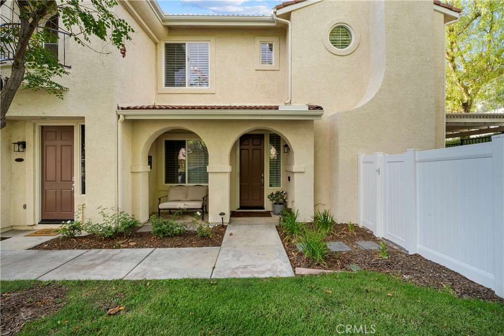 Welcome to this meticulously maintained 3 bedroom, 2.5 bathroom end corner unit in the highly sought-after Galleria at AltaVista community. Offered by the original owners, this home has been immaculately cared for and is truly turnkey and move-in ready. It has a private porch entrance with a grassy area in front. The family room is spacious enough for your biggest get togethers. The kitchen overlooks the family room and has an ample counter space, updated appliances, and endless pantry storage. The main level powder room, formal dining room and downstairs laundry room add convenience and functionality. Upstairs you’ll find three generous bedrooms and two full bathrooms. The primary suite features dual closets and dual sinks, while one of the secondary bedrooms includes a walk-in closet. Additional highlights include an attached 2-car garage with direct access and built-in storage, a private yard ideal for barbecues and entertaining guests, a Ring doorbell and keyless entry. Upgrades include travertine, wood laminate flooring, base and crown molding, built in TV entertainment center and backyard cement patio with pergola. The Galleria at Alta Vista offers wonderful amenities including a sparkling pool and park. The location is unbeatable—close to award-winning schools, shopping, dining, freeways, parks, public transportation and miles of scenic paseo trails. Don’t miss the chance to own this pristine home in one of Valencia’s most desirable neighborhoods!